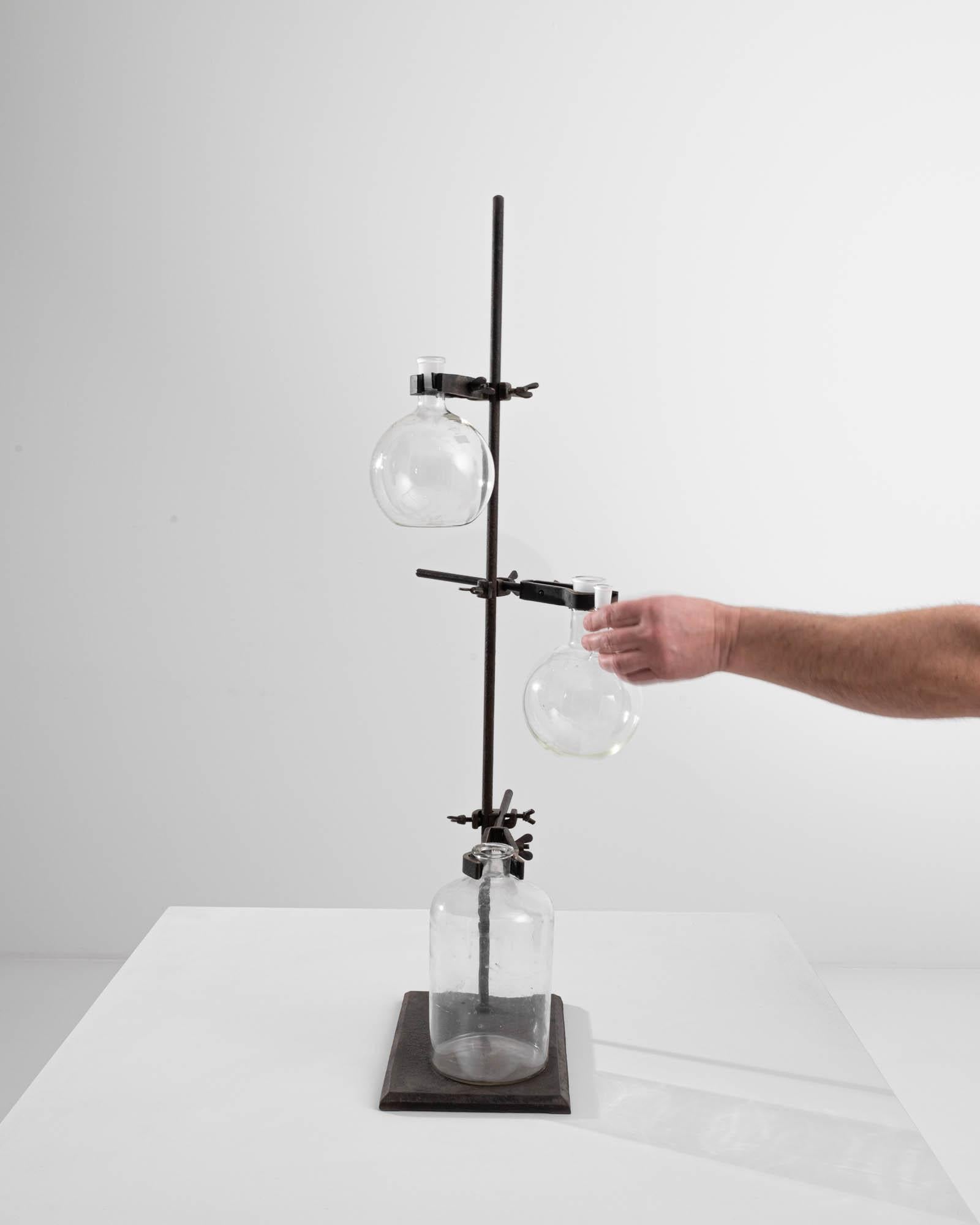 An intriguing and unique accent, this vintage lab-ware stand holds various vintage technical glasswares. Industrial, utilitarian, and scientific, yet also playful and curious, this vintage beaker holder presents a unique demeanor. Born for the