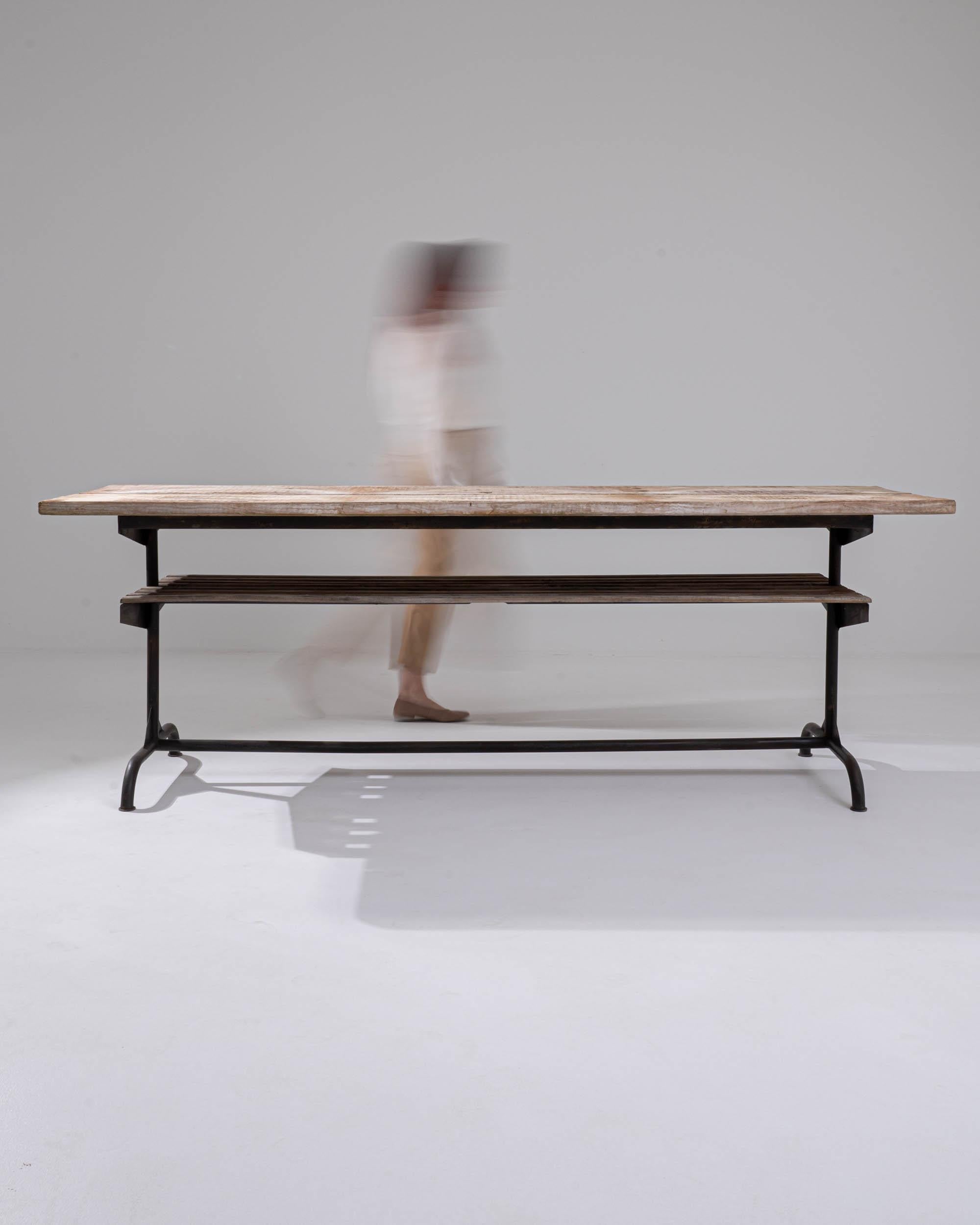 A metal table with a wooden top made in Central Europe, circa 1900. Welded metal tubes conjoin to form the legs, aprons, and stretcher of this table, upon which rests simple and eye-pleasing planks of wood. Composed with a lower shelf and a generous