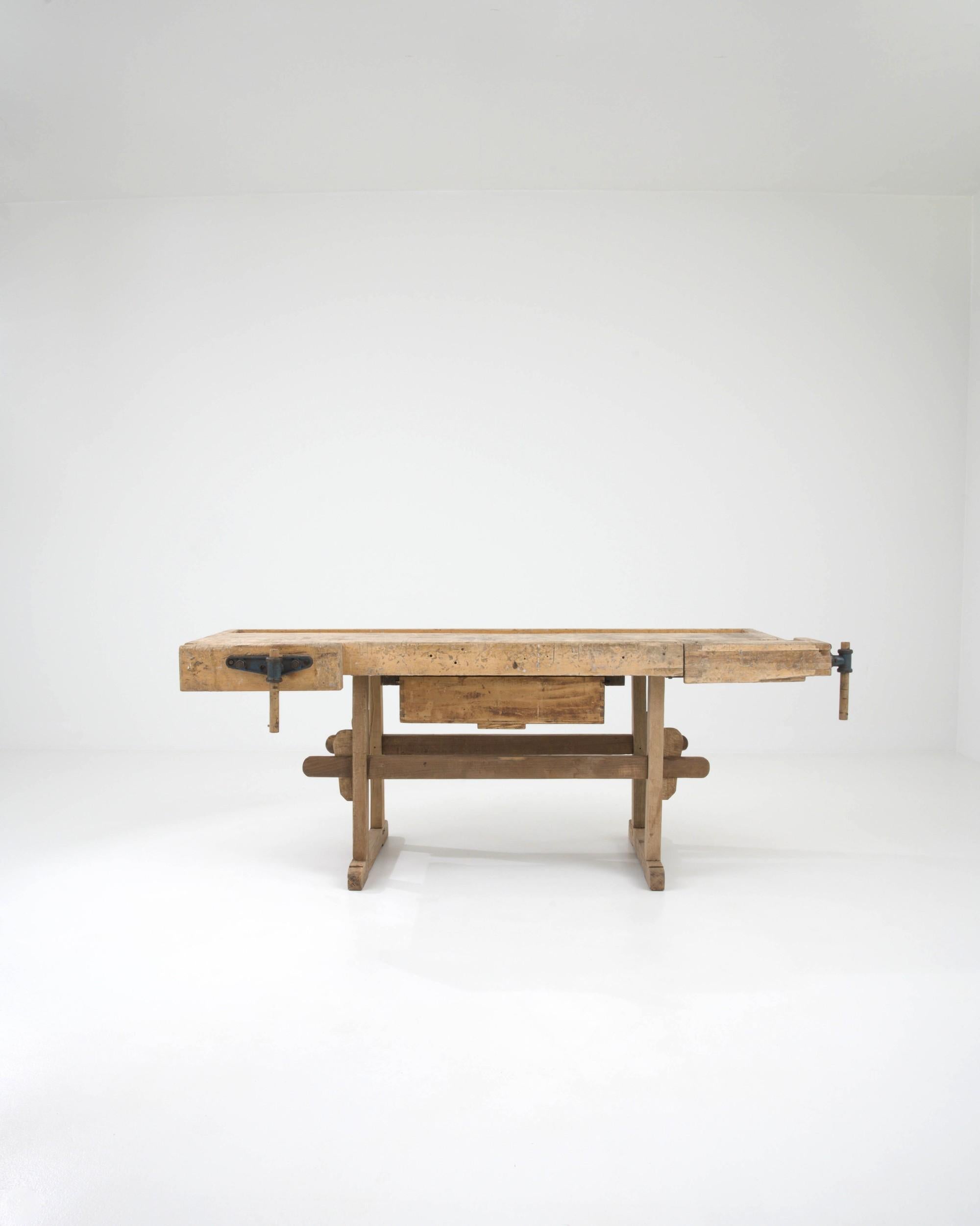 Robust and pragmatic, this vintage wooden work table cuts a handsome Industrial silhouette. Built in Central Europe in the 20th century, this piece would have originally formed part of a carpenter’s workshop. Every detail of the form serves a