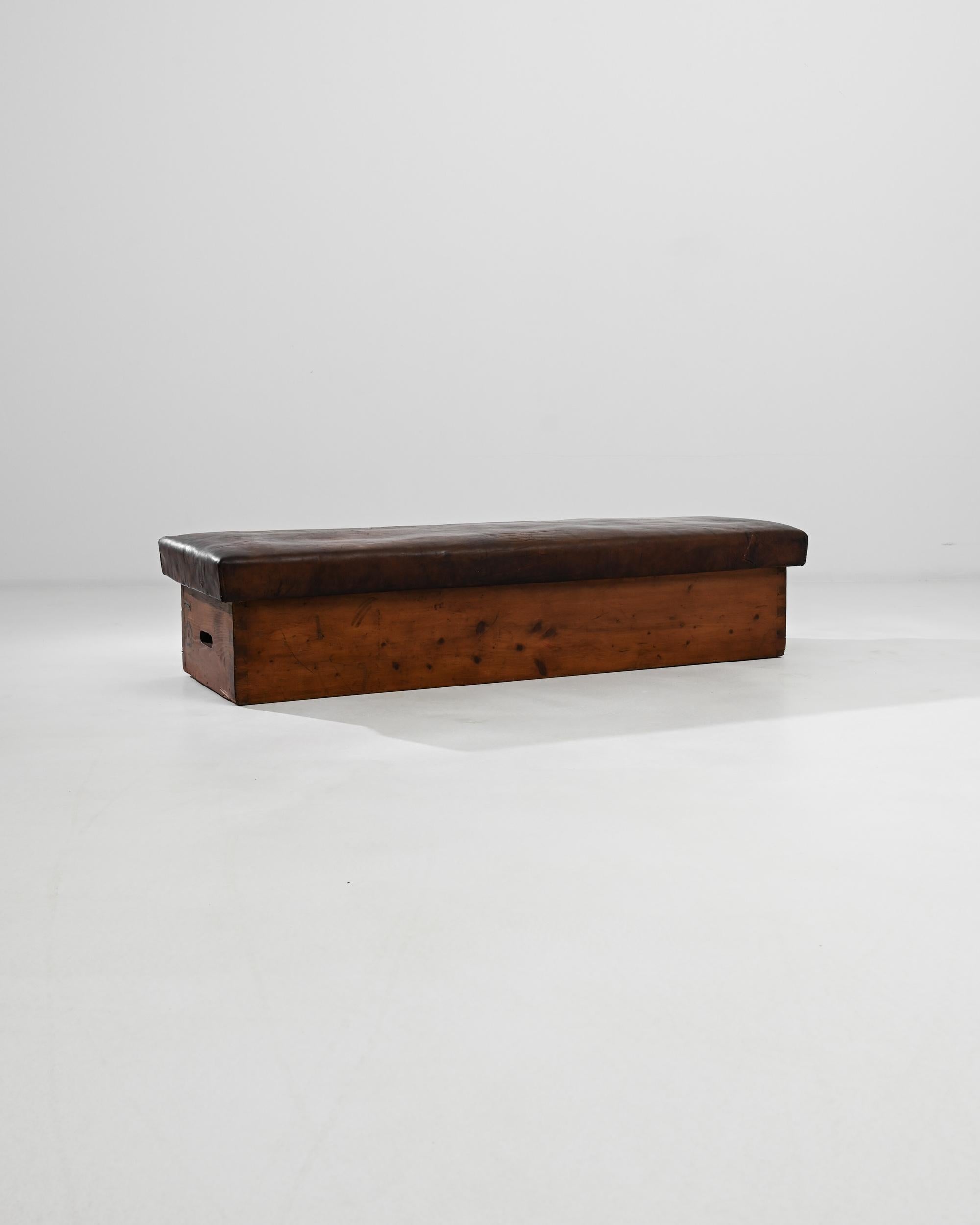 A vintage leather pommel horse from Central Europe. This long, unique bench, built for exercise, glows with a special warmth. Hand-stitched leather and box joints assemble this elegant and minimal piece. This bespoke bench emits a sense of