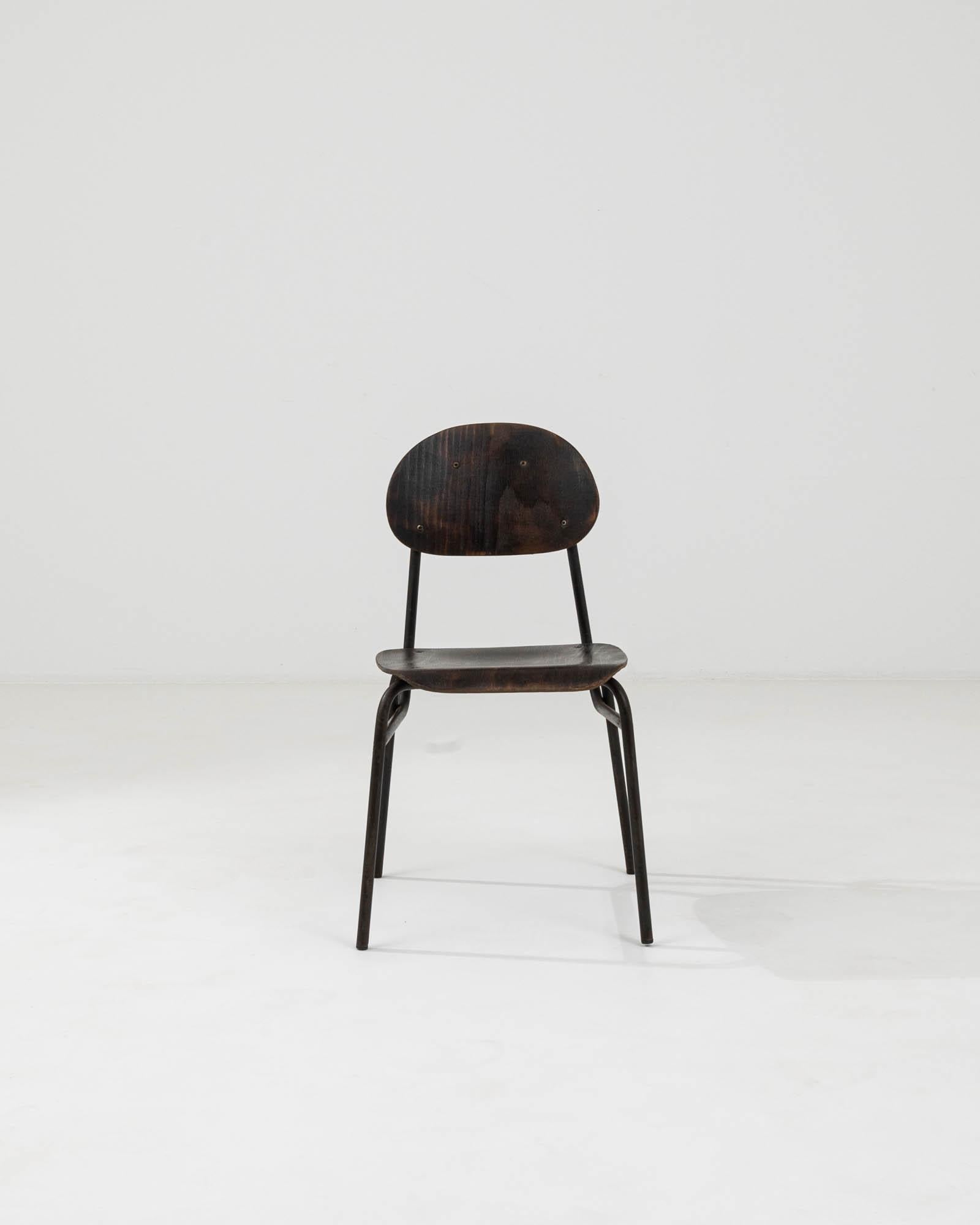 Entrez dans un monde où le design classique rencontre une fonction durable avec cette chaise en métal et bois d'Europe centrale du XXe siècle. Cette pièce singulière illustre l'art de l'artisanat intemporel, avec une structure métallique élégante