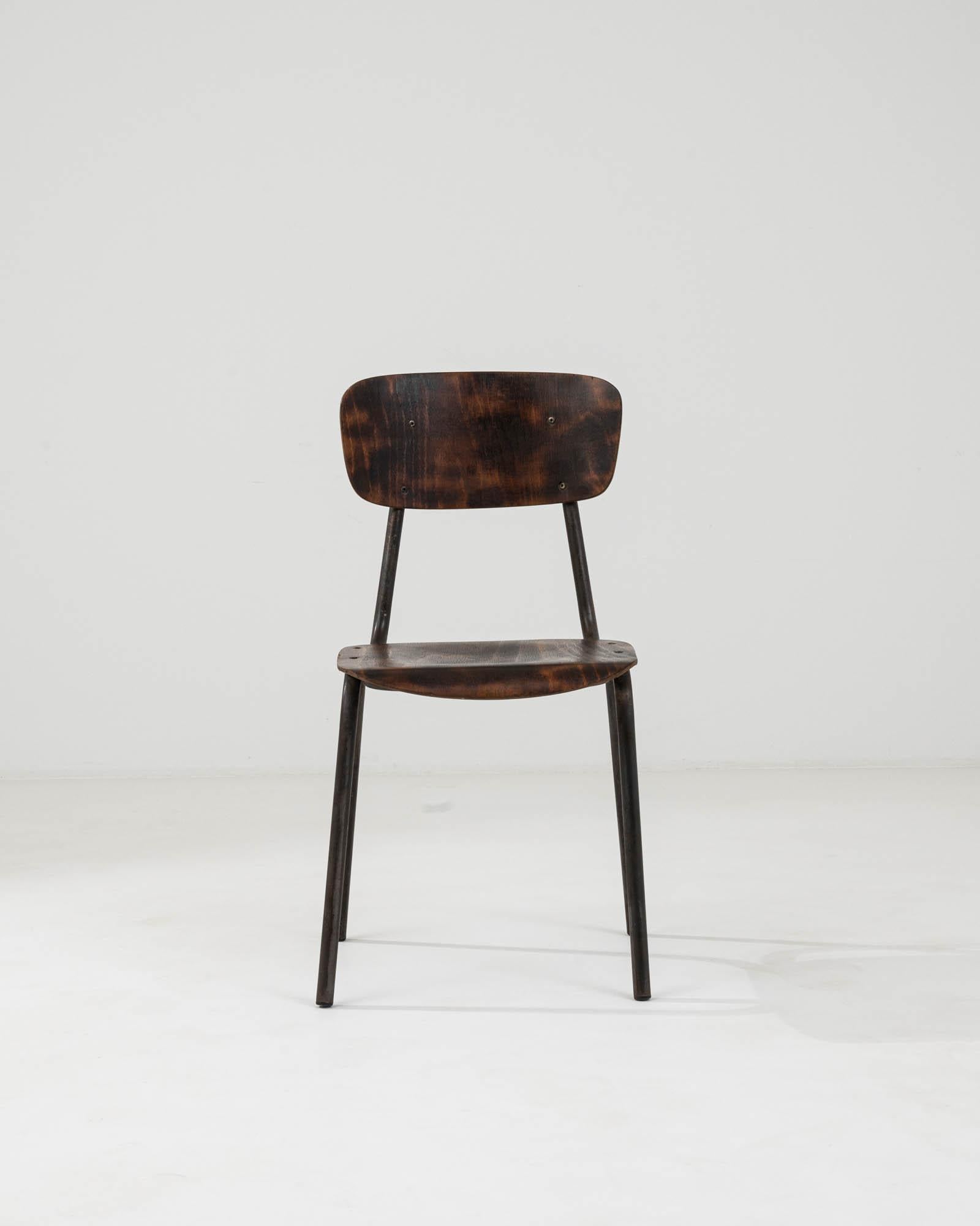 Entrez dans un monde où le design classique rencontre une fonction durable avec cette chaise en métal et bois d'Europe centrale du XXe siècle. Cette pièce singulière illustre l'art de l'artisanat intemporel, avec une structure métallique élégante