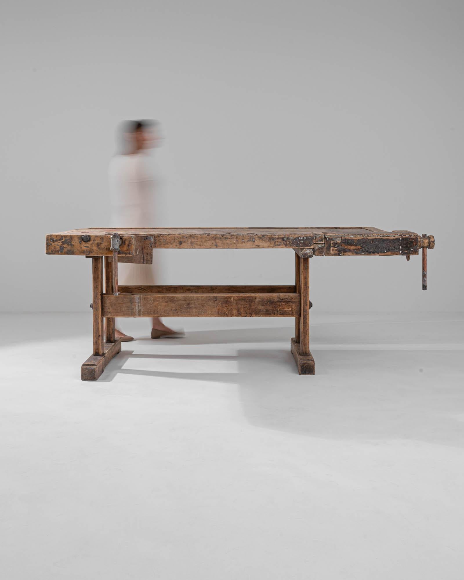 Die Kombination aus beruhigender Solidität und stimmungsvoller Patina verleiht diesem Vintage-Arbeitstisch aus Holz einen zeitlosen industriellen Charme. Das asymmetrische Design, das im 20. Jahrhundert in Mitteleuropa gebaut wurde, ist durch und