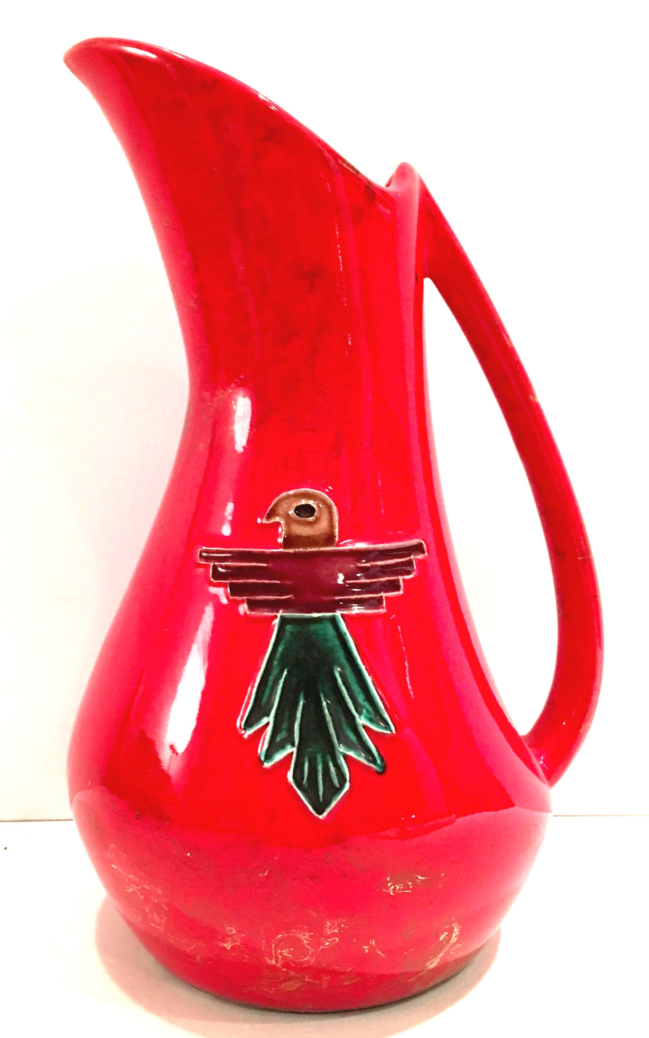 Mid-20th century ceramic glaze pottery, fire engine red with gold metallic detail and reposse Thunderbird hand painted detail five piece drinks set. Set includes handled pitcher and four tumblers. Tumblers measure, 4
