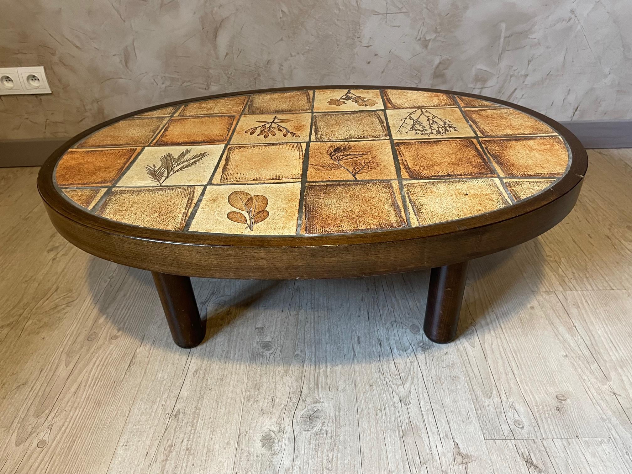 Very nice French Roger capron Valauris coffee table from the 1960s. 
Ceramic tile top en wooden base representing different kind of leaves. 
Nice oval shape with a wooden base.
 