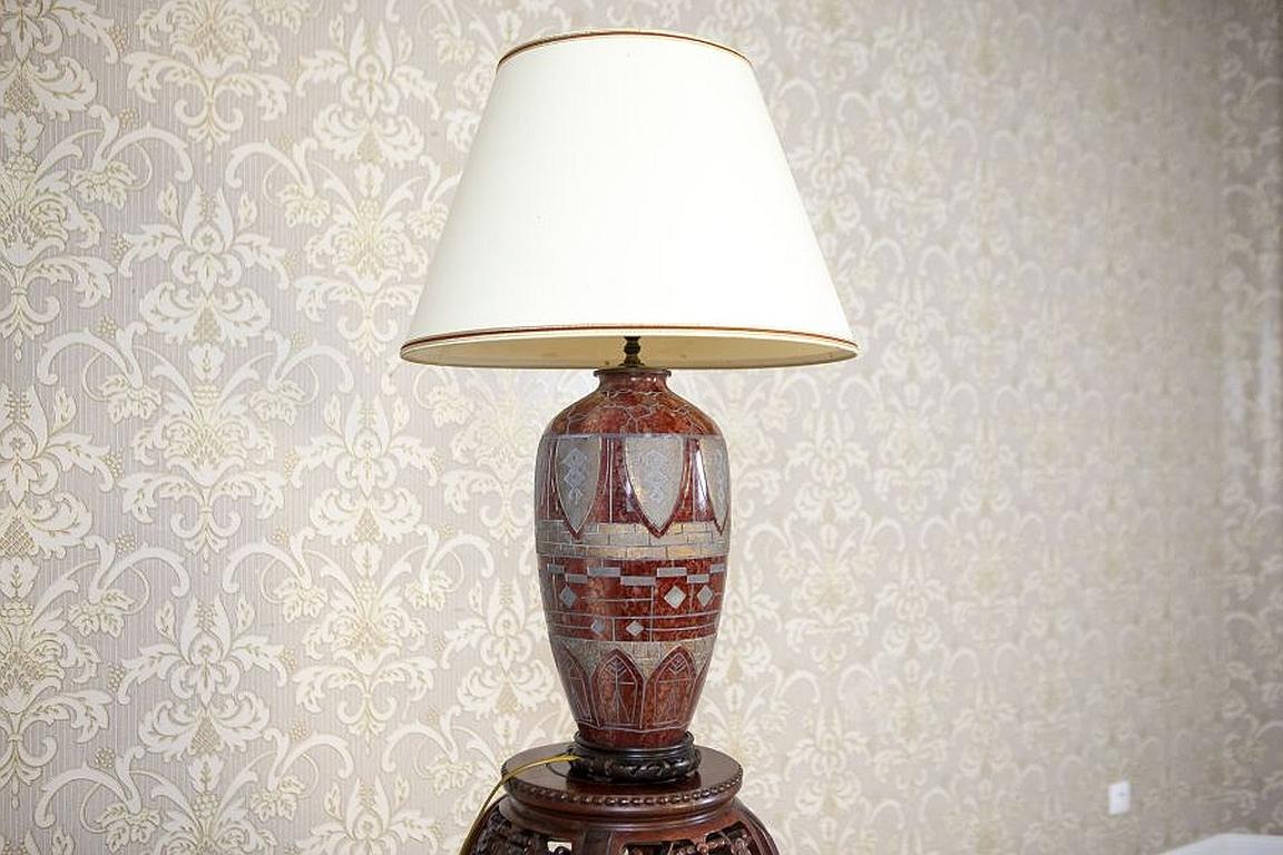 20th-Century Ceramic Table Lamp on Wooden Base

We present you this ceramic lamp from the 2nd half of the 20th century on a wooden base, which is decorated with geometrical shapes. The shade in the form of a cone is made of material and bears traces