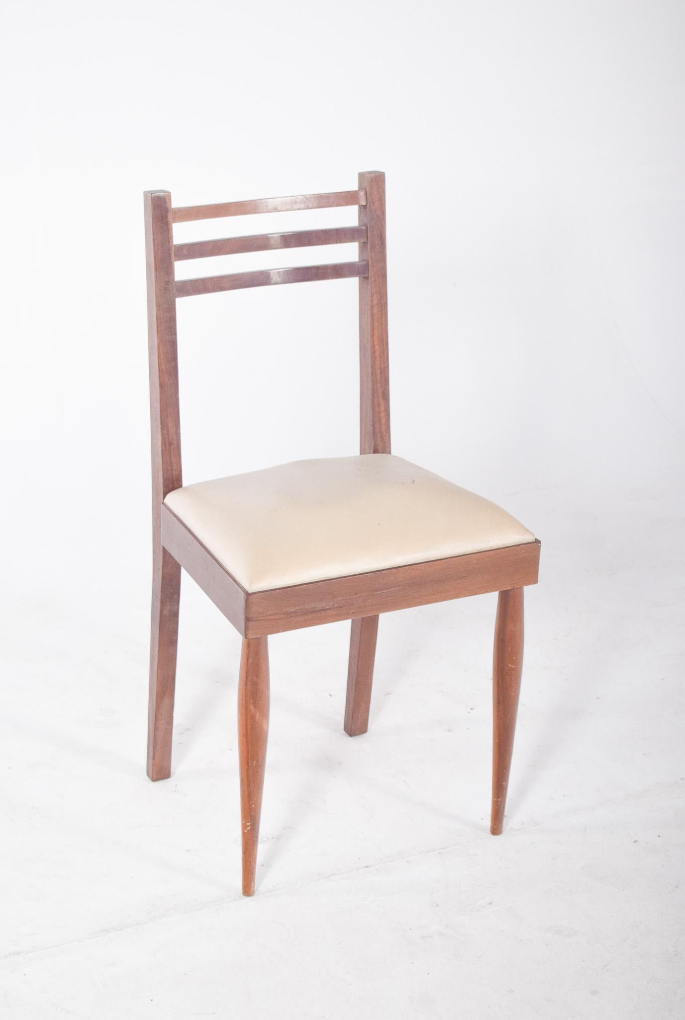 Stuhl mit drei Latten an der Rückenlehne. Der mit weißem Synthetikstoff bezogene Sitz ist schlicht und funktional, mit geraden Linien und diskreten geometrischen Formen, die an den modernen Stil der Mitte des Jahrhunderts erinnern. Die Rückenlehne