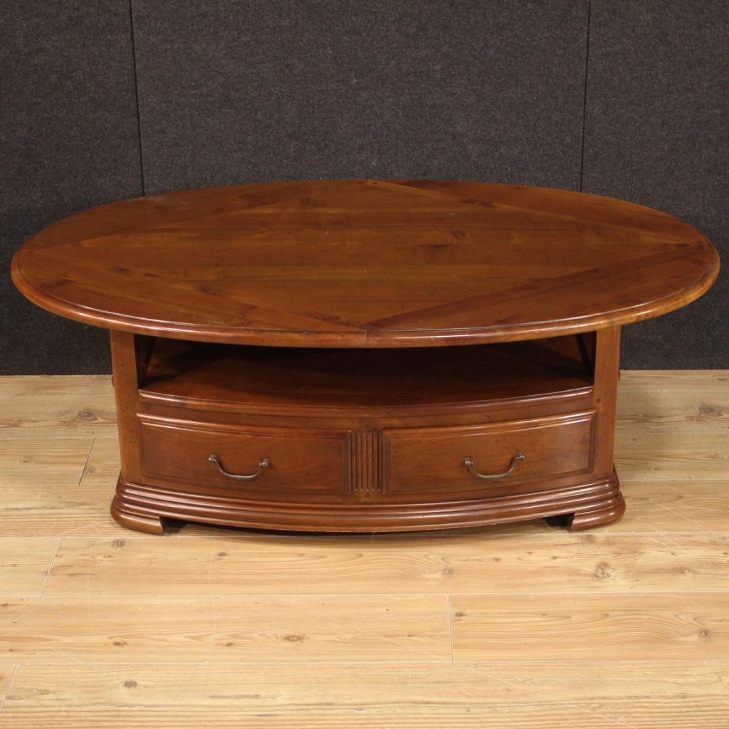 French coffee table from the late 20th century. Furniture in cherry wood and fruitwood of beautiful line and pleasant decor. Table equipped with two drawers, a pull-out side shelf (see photo), upper oval top and lower magazine rack. Ideal furniture