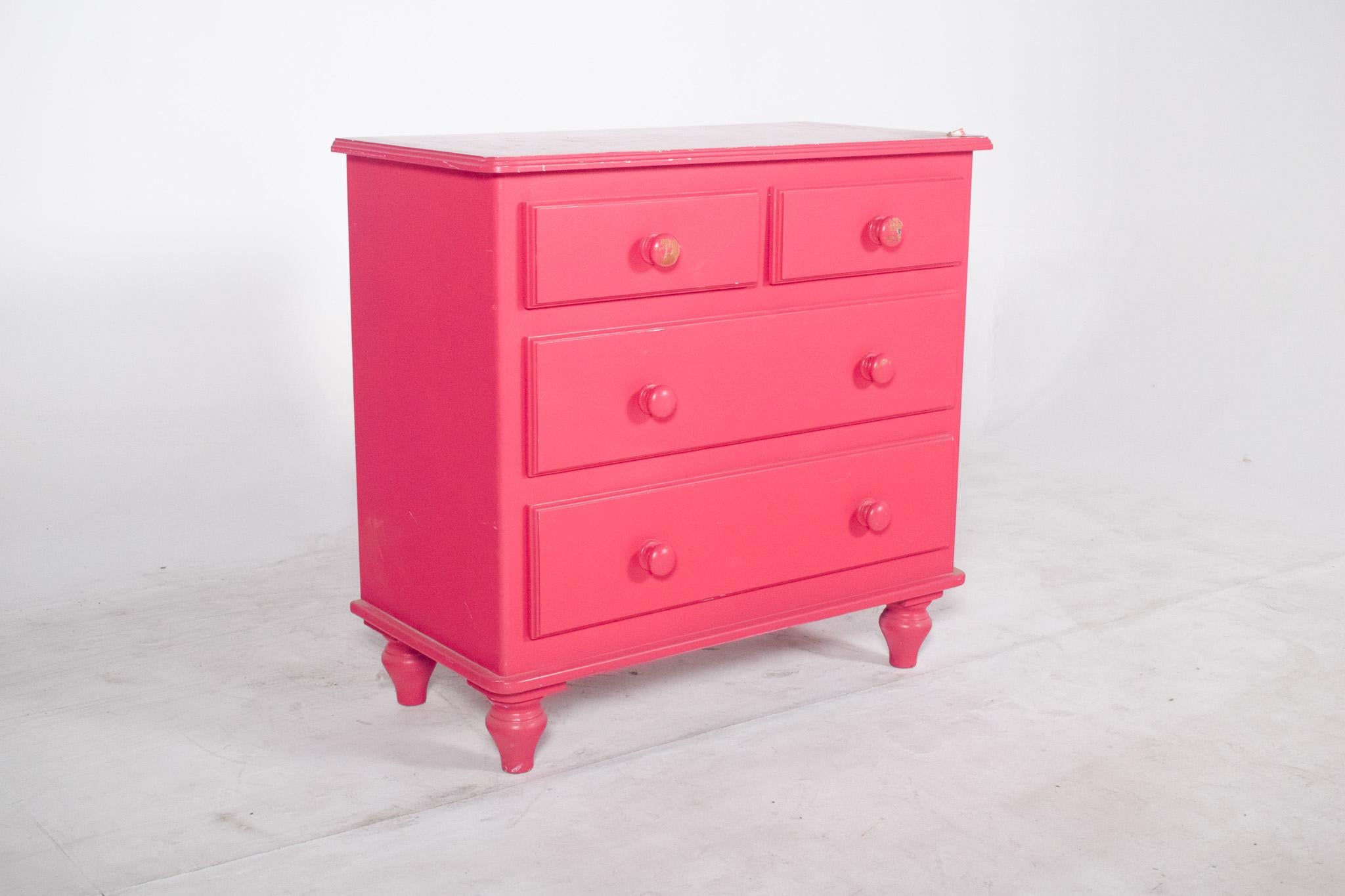 Chest of drawers painted pink. Finished in a vibrant shade of pink, the chest of drawers has a playful, contemporary feel with classic inspiration. The structure has simple, well-defined lines, with four drawers in a traditional arrangement, two