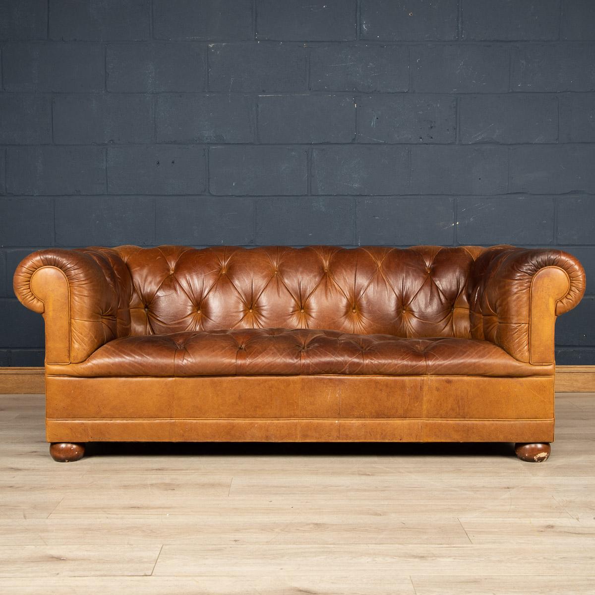 A superb leather Chesterfield sofa retailed by Laura Ashley around the latter part of the 20th century. One of the most elegant models with button down seating, this is a fashionable item of furniture capable of uplifting the interior space of any