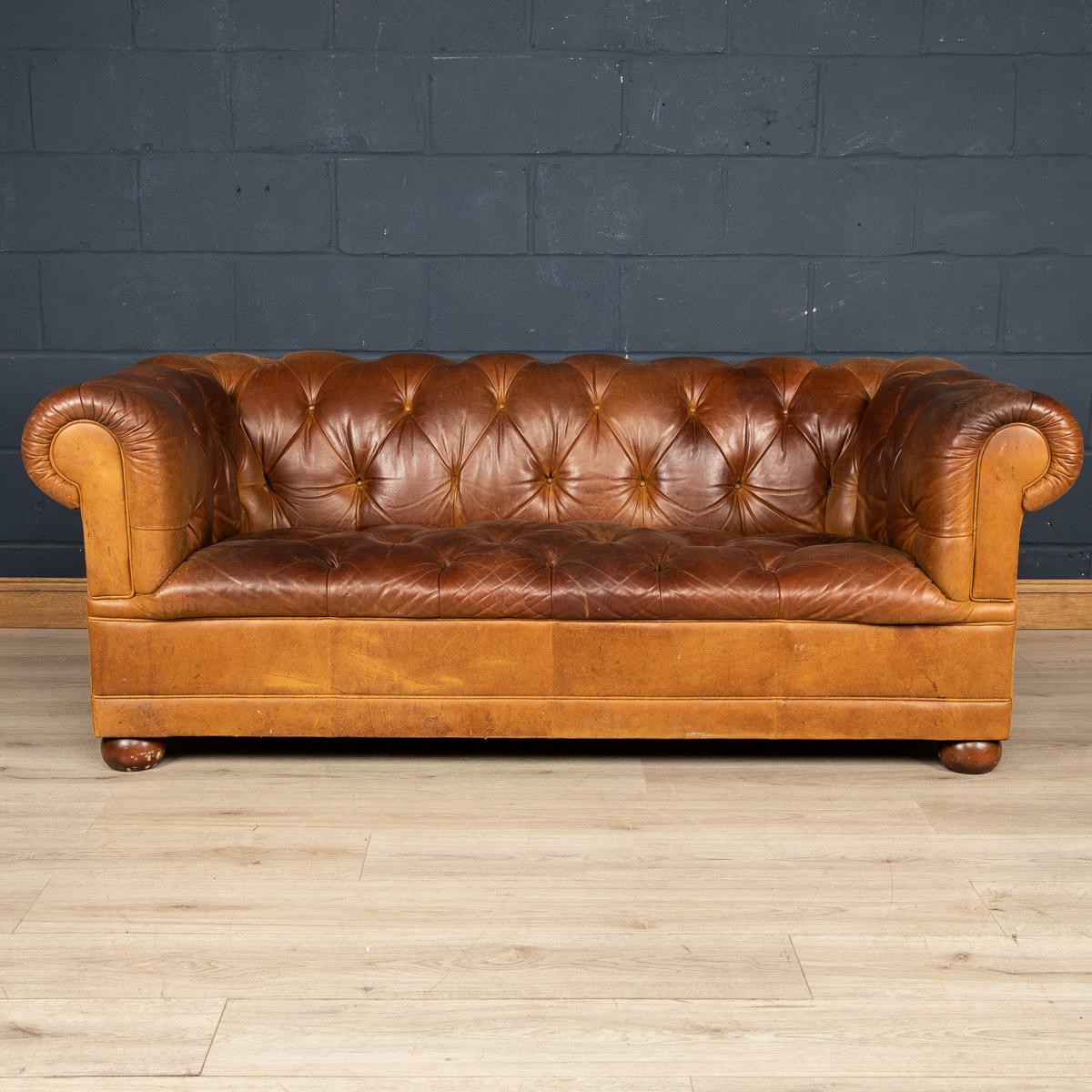 A superb leather Chesterfield sofa retailed by Laura Ashley around the latter part of the 20th century. One of the most elegant models with button down seating, this is a fashionable item of furniture capable of uplifting the interior space of any