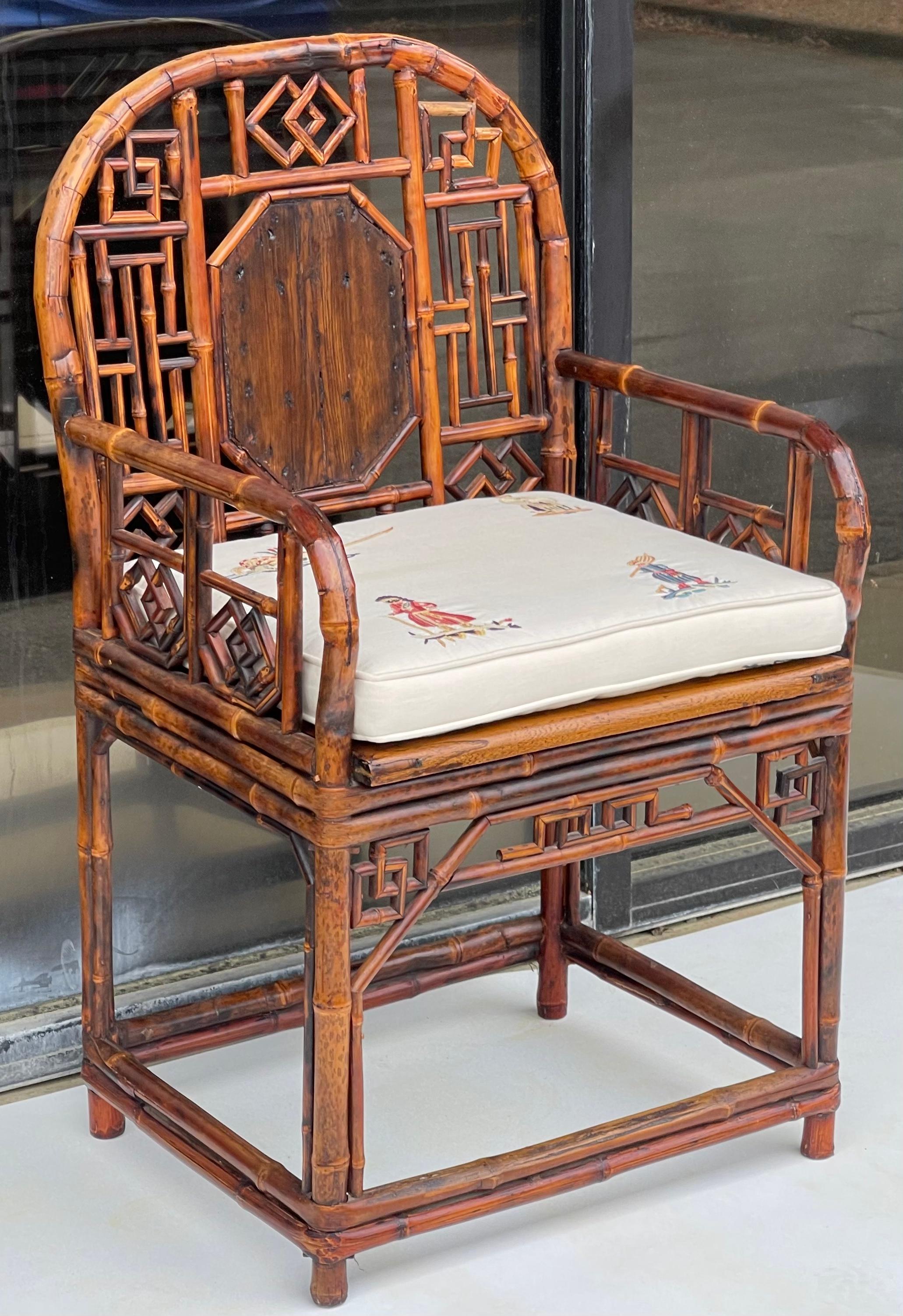 This is a wonderful Chinese Brighton style burnt bamboo arm chair. It has a vintage embroidered linen cushion that does show slight wear. It is in very good condition.