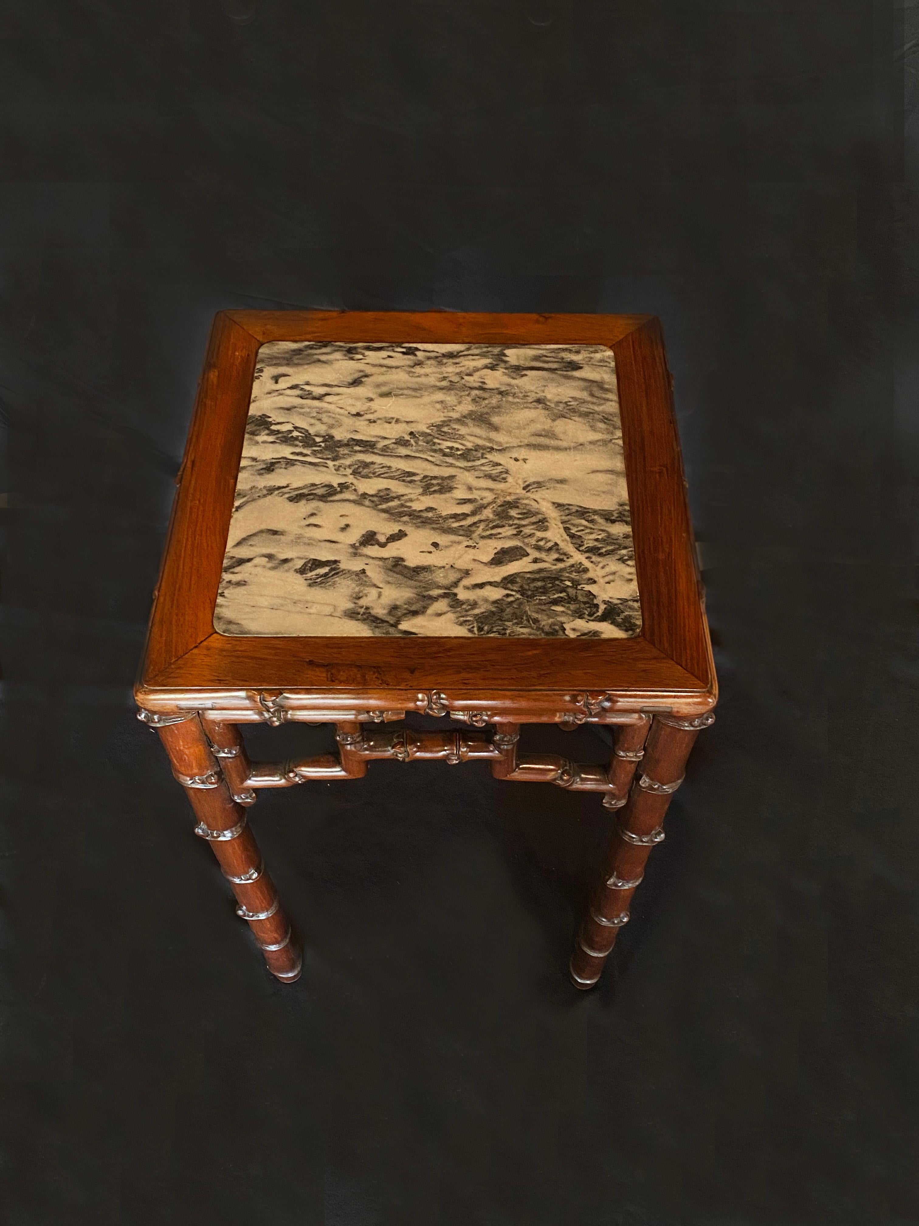 Chinese mahogany and marble side table. An elegantly simple shape with intricate Chinese design details. The wood has been carved to imitate bamboo and the table top features a beautiful black and white marble. A beautiful piece of furniture to add
