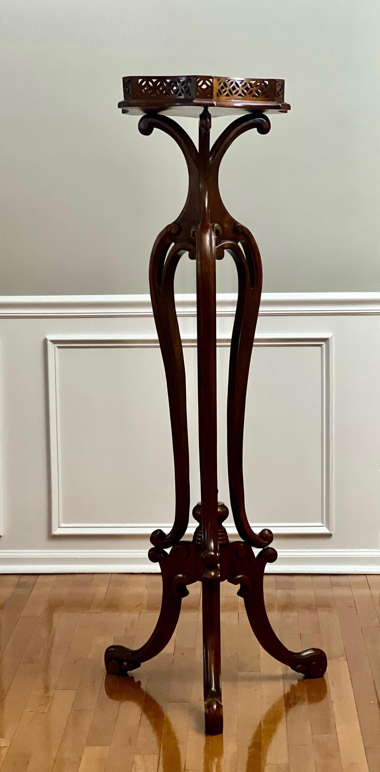 Chinese Chippendale style tall rosewood pedestal stand, 20th century.

Magnificent large carved pedestal with fretwork gallery on a shaped top and three scrolled legs with openwork. Sculpted legs have a tiered appearance as they meet the base with a