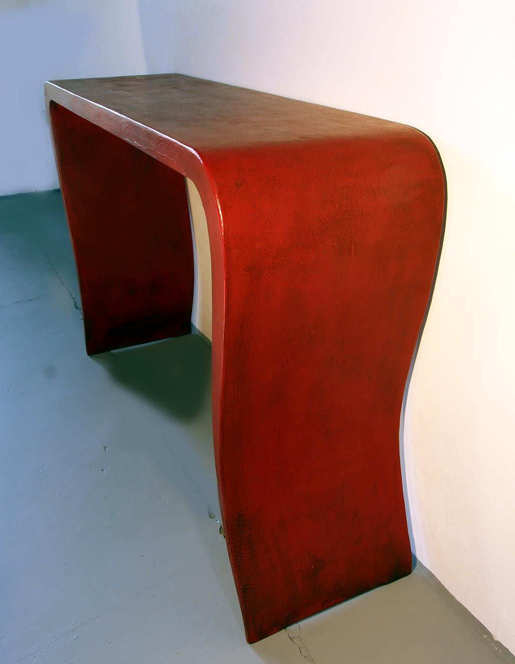 Special silhouette of this shaped console in china red lacquer in solid wood.