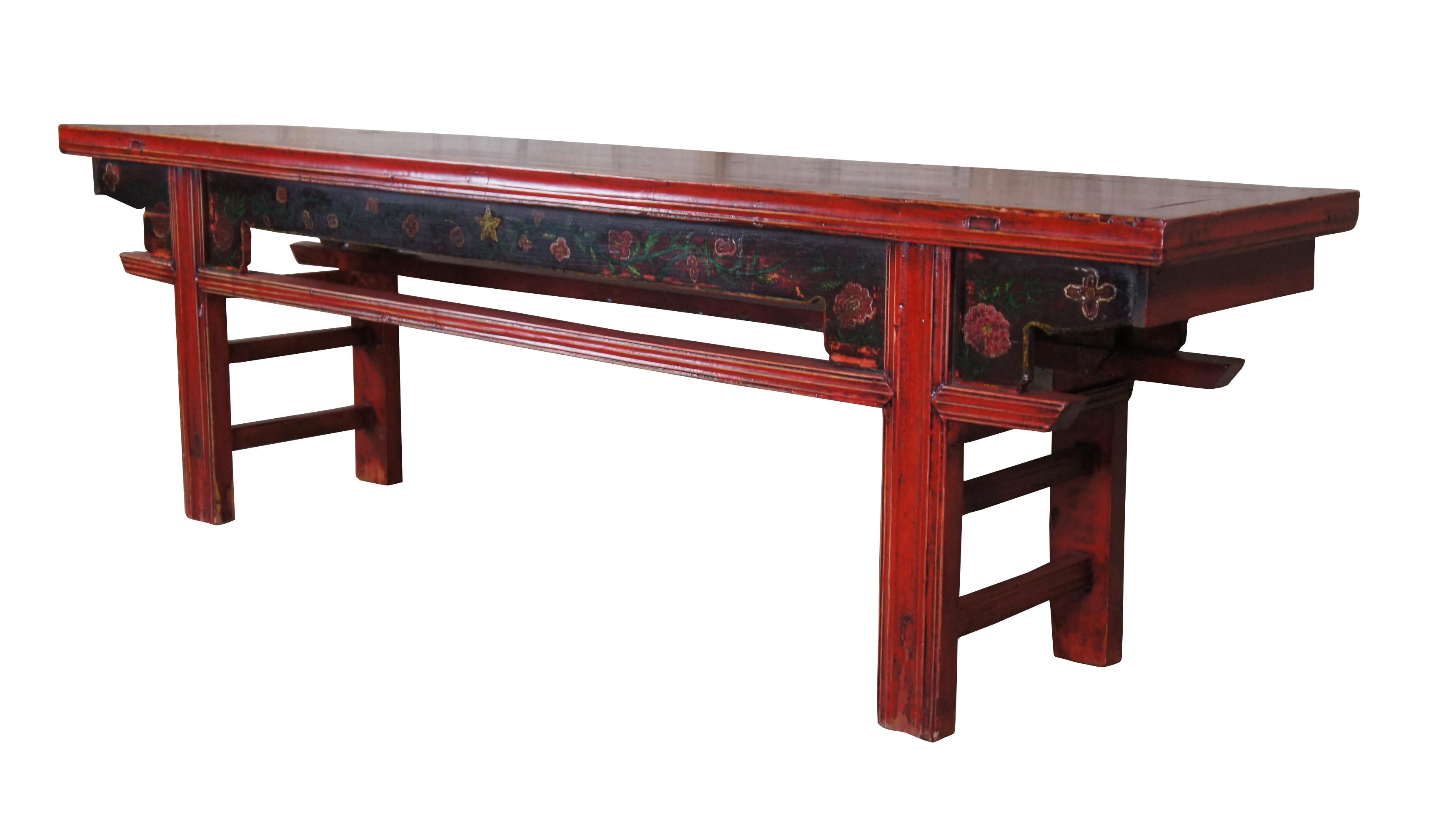 20th Century vintage Chinese chinoiserie hallway bench or pew. Made from Elm featuring rectangular form with red lacquer finish and folk painted floral and star motif. Constructed via mortise and tenon joinery.