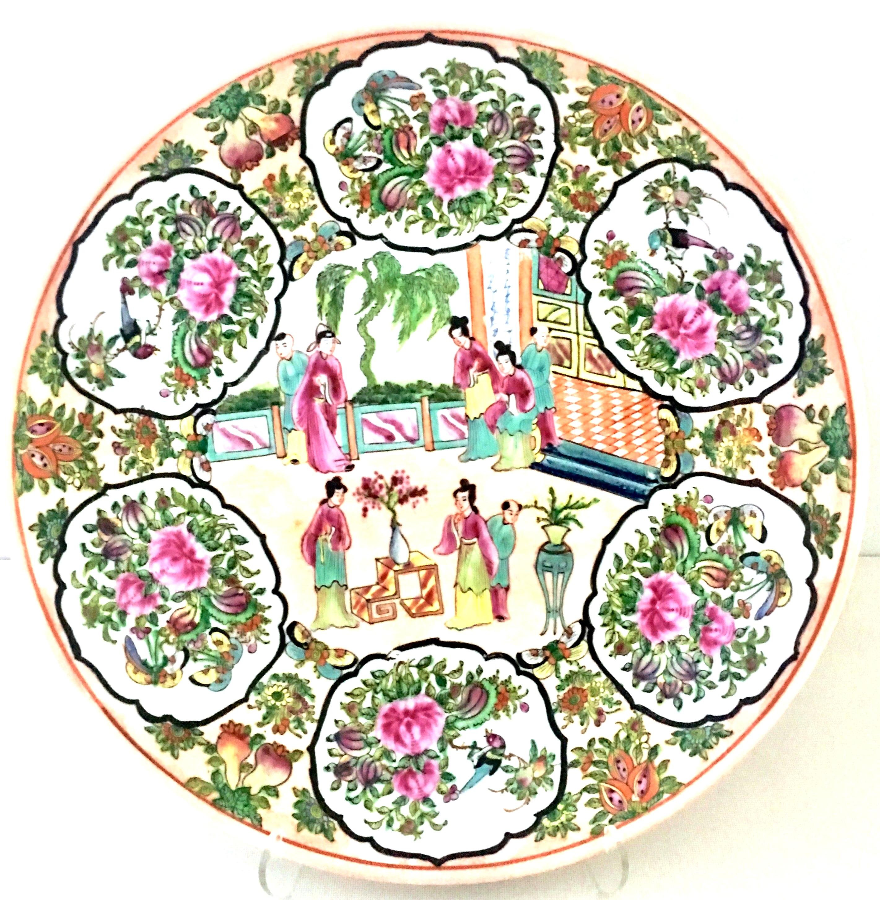 20th century Chinese Export porcelain hand painted Famille center bowl. Features a bright white ground with pink, peach, black and multi-color ladies in a courtyard scene with giant lotus motif detail. Signed on the underside with six symbol red