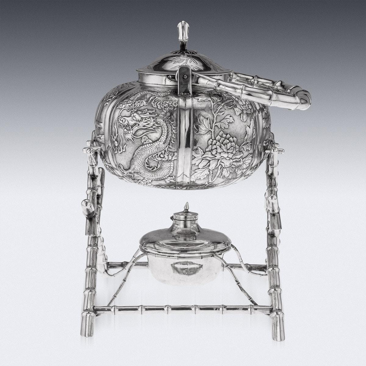 Antique early 20th century Chinese export solid silver tea kettle on stand, the body chased in relief with floral decoration, the domed lids mounted with a bamboo finial. The kettle is suspended on a stylised, well constructed bamboo stand, with a