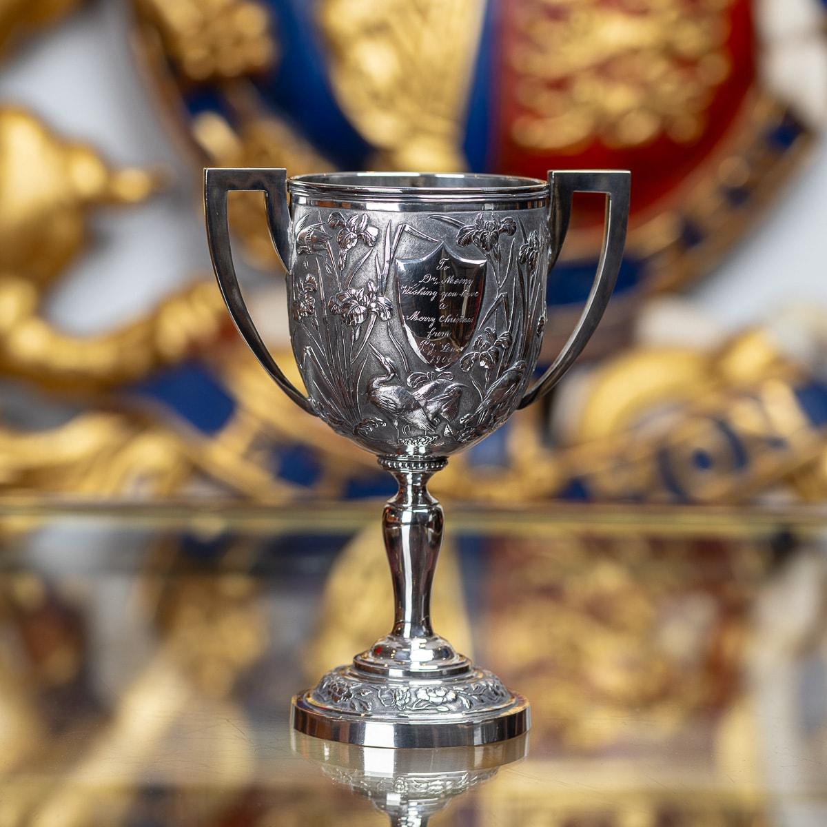 Antique early 20th Century Chinese export solid silver trophy cup, impressive and exceptionally fine quality, decorated with iris and perched exotic birds against a hand chased matted ground, cup resting on an elegant shaped stem and turned domed