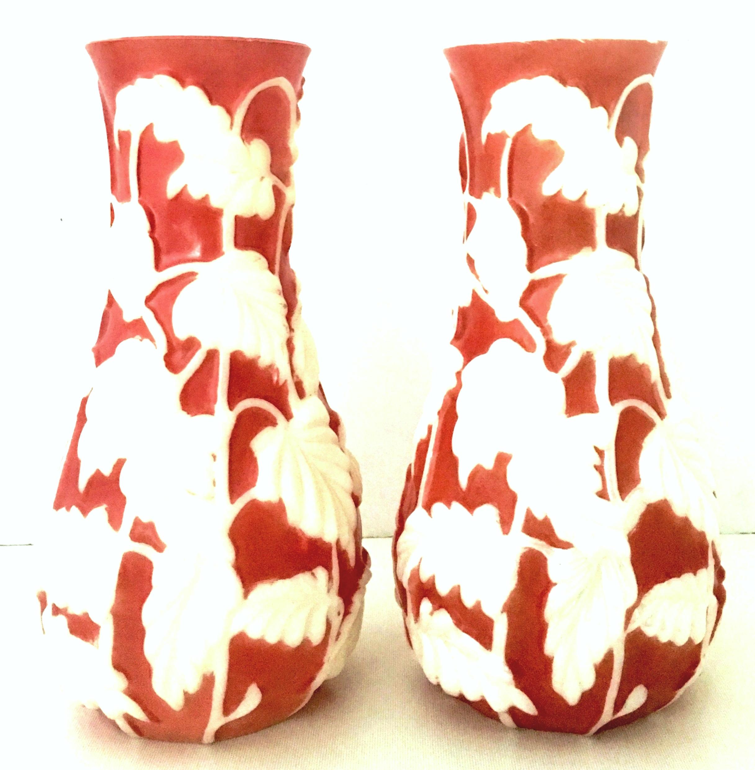 20th century pair of Phoenix art glass high relief vases. This lovely rare and coveted pair of Peking glass vases feature a rose colored ground with high relief white iridescent floral and vine motif.
 