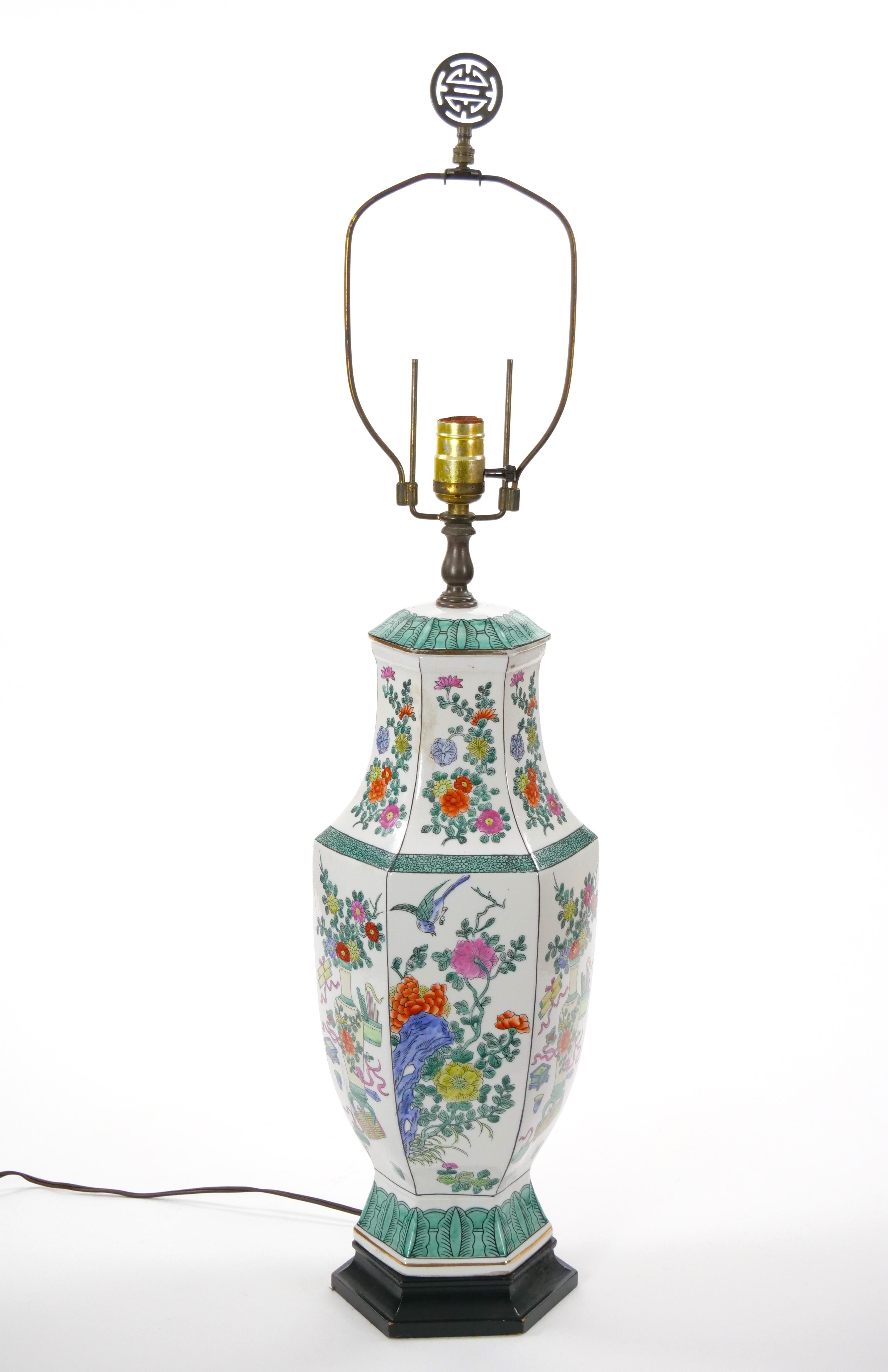Questa elegante lampada da tavolo in porcellana cinese del XX secolo presenta un corpo classico a forma di urna con un collo graziosamente affusolato, con un delicato disegno floreale e fogliare all'esterno. Gli intricati dettagli dipinti a mano