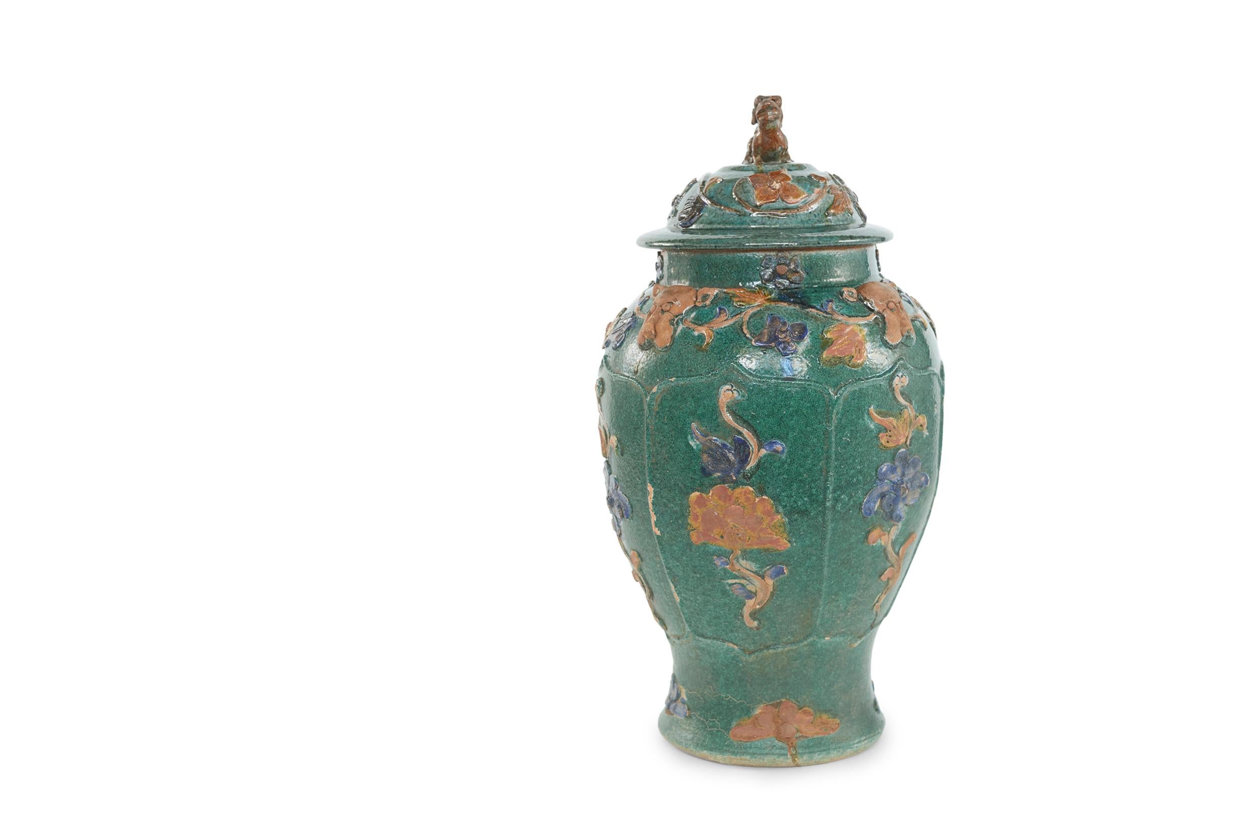 Early 20th century Chinese Sancai glazed earthenware decorative covered jar of an amphora shape & body featuring a continuous motif of blue & red clay flowers, the neck featuring a continuous motif of a flowering vine alternating with dog of Foo