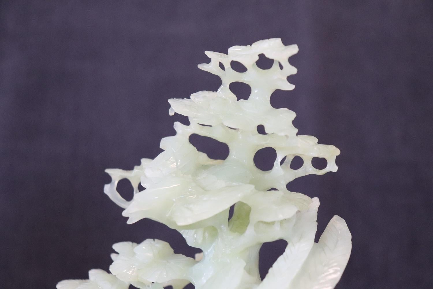 20. Jahrhundert Schöne Skulptur aus kostbarer grüner Jade, hergestellt in China. Hohe künstlerische Qualität eines Baumes mit vielen Blättern, zwischen dessen Ästen einige Vögel zu sehen sind. Die Skulptur ruht auf einem Holzsockel. Perfekte