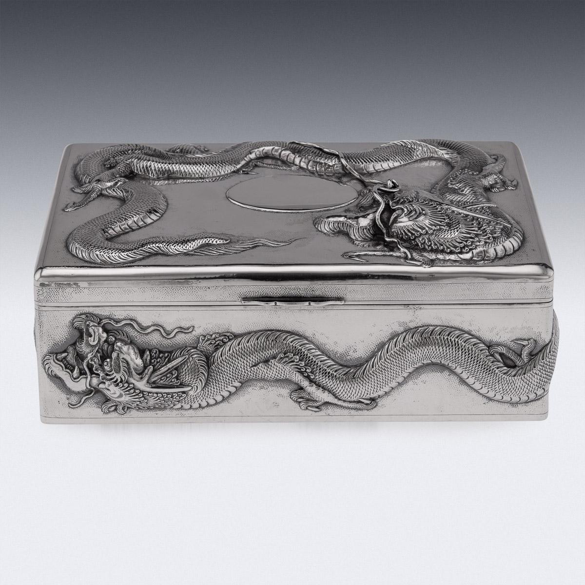 Antique early-20th Century Chinese export period solid silver large cigar box, sides and the lid are embossed in high-relief with dragons and applied with flowing whiskers on hand hammered ground, with a vacant oval cartouche, inside wood lined.