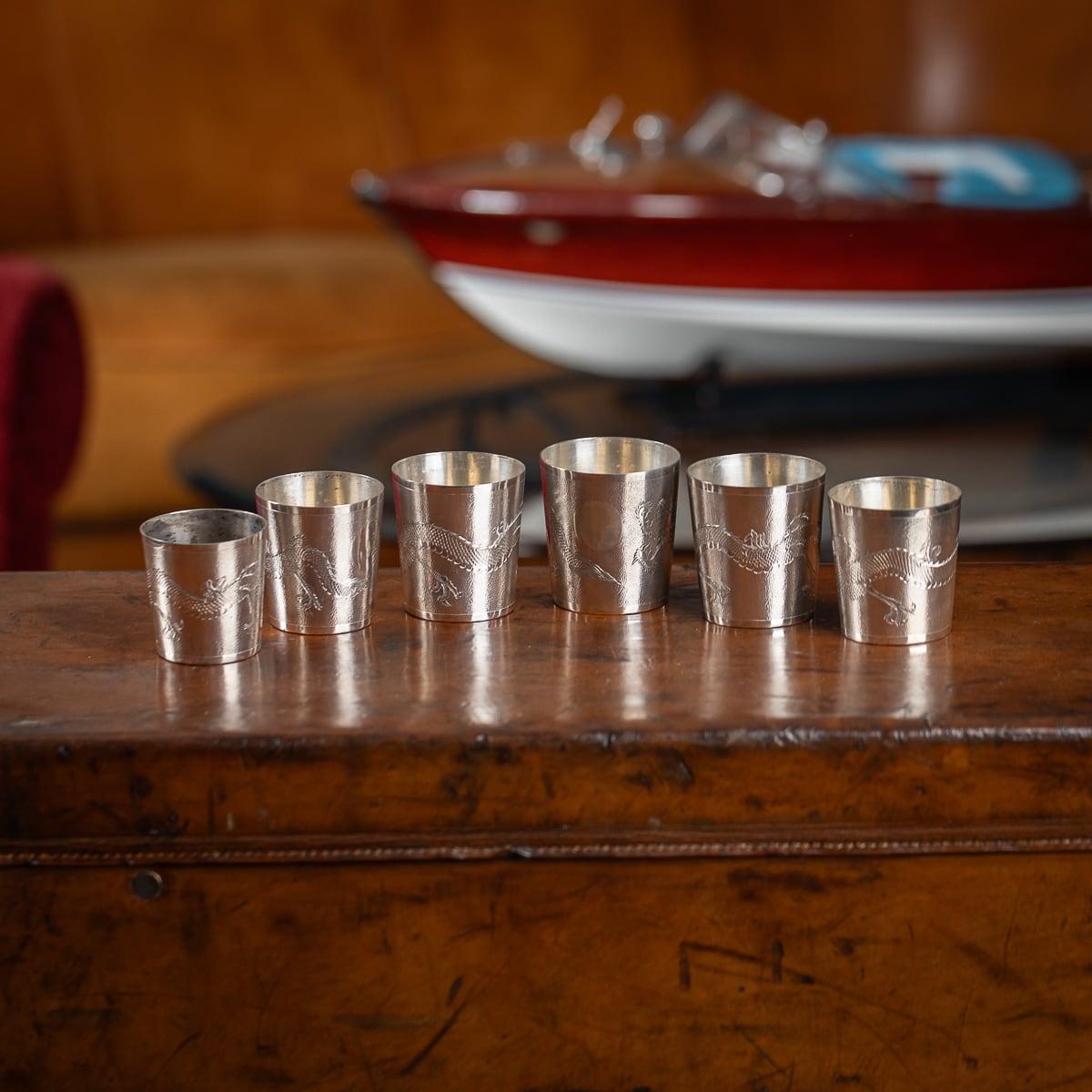 Antique 20th Century Chinese solid silver set of six stackable cased cups with leather pouch. The cups with a smooth top rim, a hand beaten hammer effect with a dragon which encircles the body. The underside of each cup is smooth and stamped with
