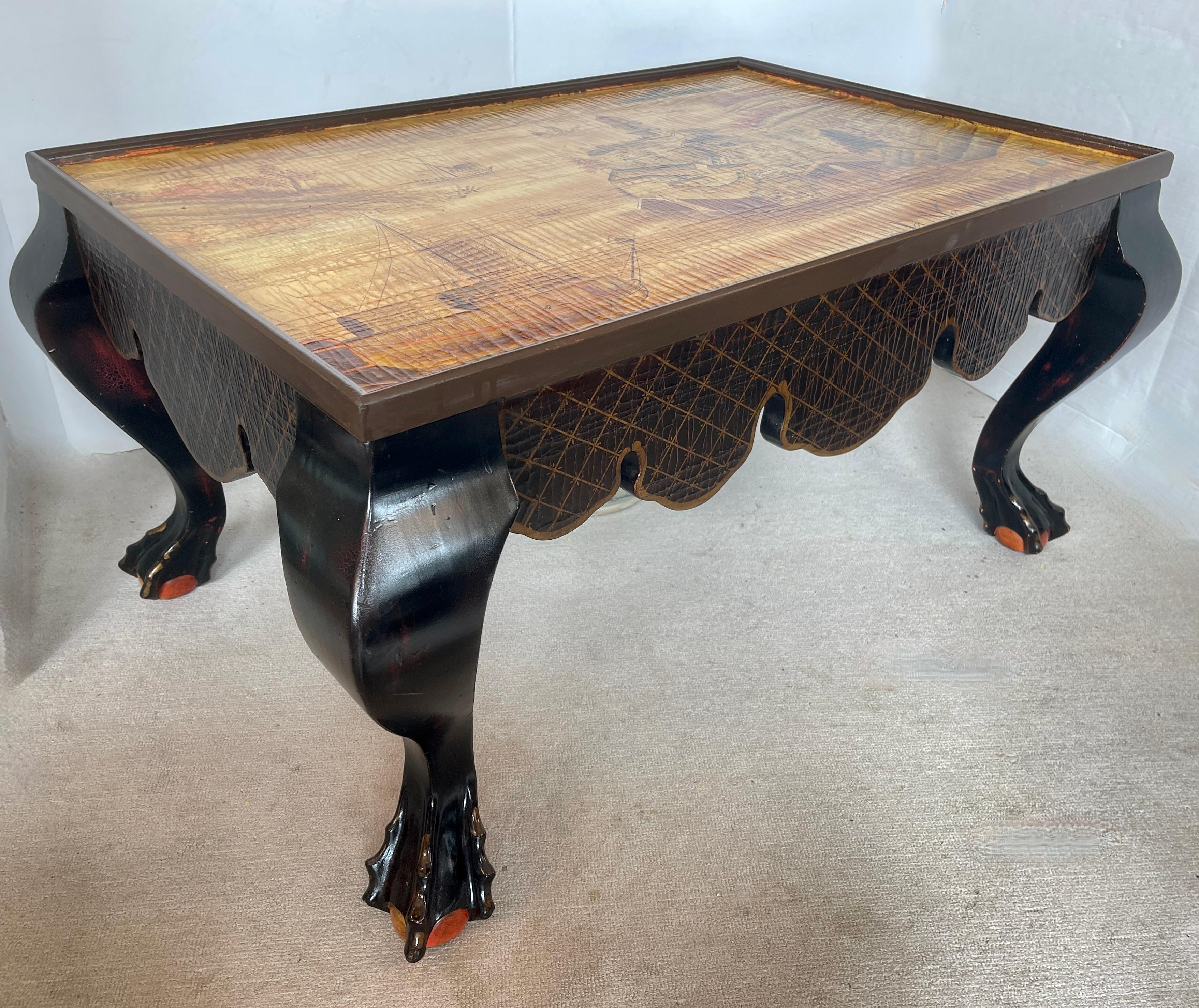 Tout juste arrivé dans le magasin aujourd'hui !
Ce 20e siècle. Table de cocktail en laque Chinoiserie avec de larges pieds cabriole en Boule et Pieds griffes.
Le plateau de la table représente une scène de campagne asiatique et un paysage marin dans