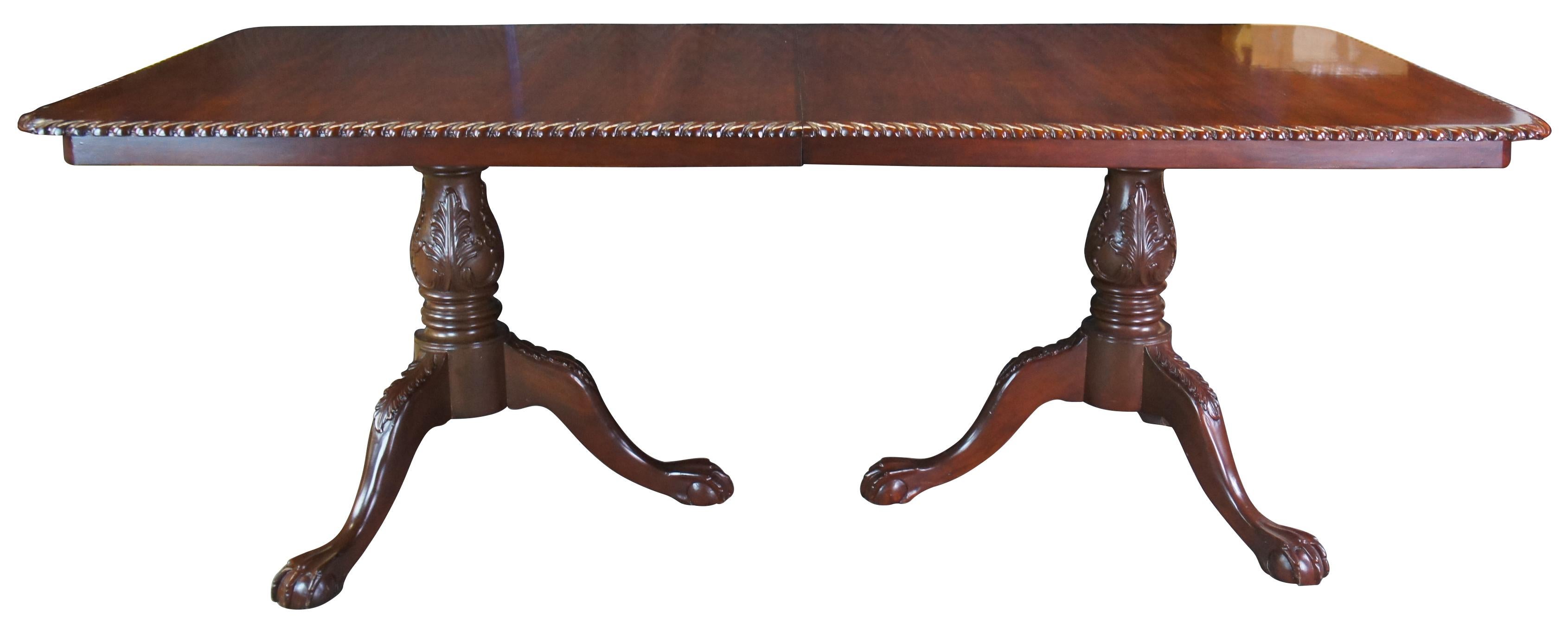 Exquisite chippendale style dining table, circa 1980s. A rectangular form made from mahogany with two extendable leaves. The table is supported by acanthus carved pedestal leading to ball and claw feet. Features a thick decorative edge of