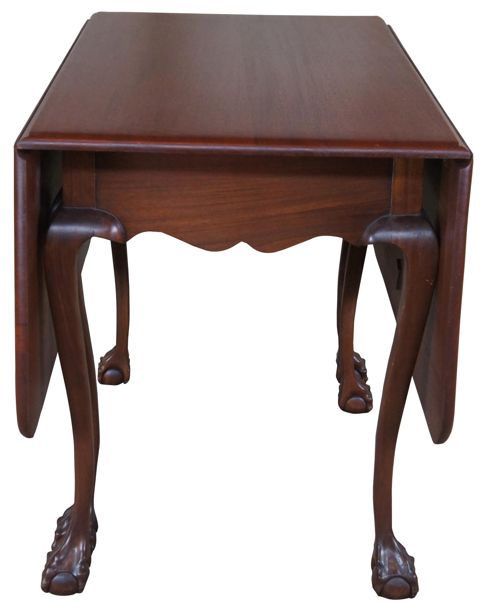 20th century drop leaf gateleg dining table. Made of mahogany featuring a rectangular form with serpentine apron. Features two large drop leaves and six legs with ball and claw feet.

Measures: 44
