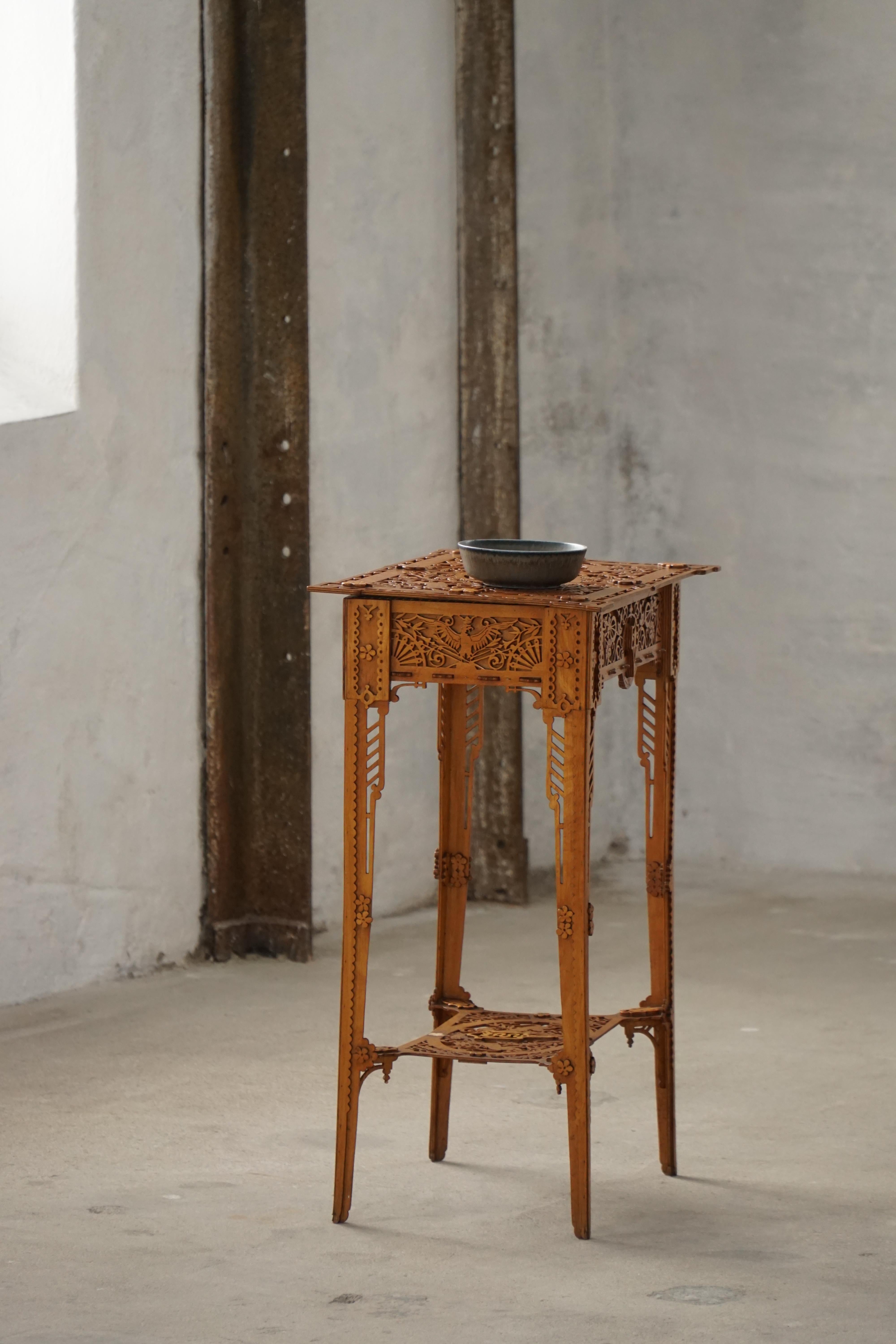 Consolle o tavolino finemente intagliato in stile Chippendale, realizzato nel XX secolo. Il tavolo è dotato di un piano incernierato che si apre su un vano portaoggetti rivestito in tessuto blu trasparente, diviso in tre sezioni: una grande e due