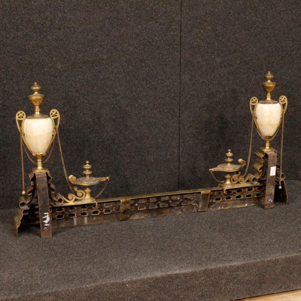 Italian decor for fireplace from the first half of the 20th century. Object in chiseled bronze and brass of excellent quality adorned with side cups in onyx. Extendable andiron that can decorate the front of a chimney from the following maximum