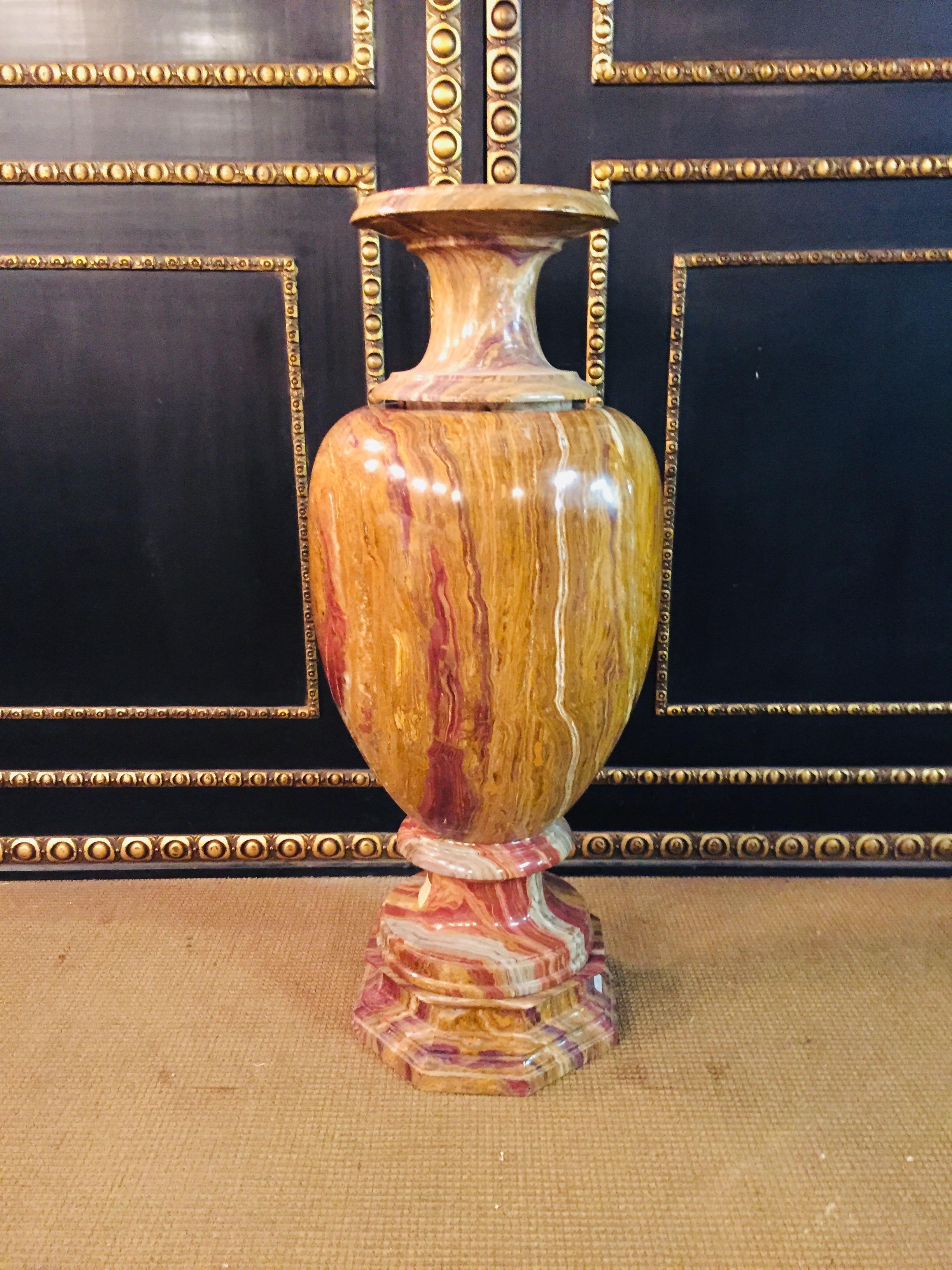 Monumental marble crater vase in classicist style. Natural marble in red onyx. Round foot on octagonal formed plinth on sweeping shaft. Ovoid body, lightly conical, ascending neck and wide protruding, convex and profiled edge. The whole crater vase