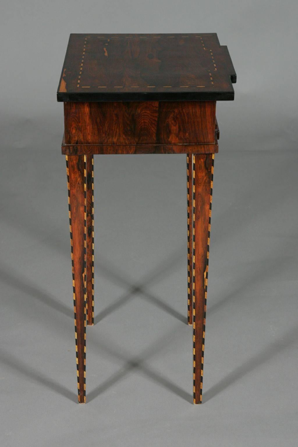 Occasional table in Classicist style.
Palisander on pinewood, framed fields of marquetry from band Intarsia. 

(G-Sam-20).
 