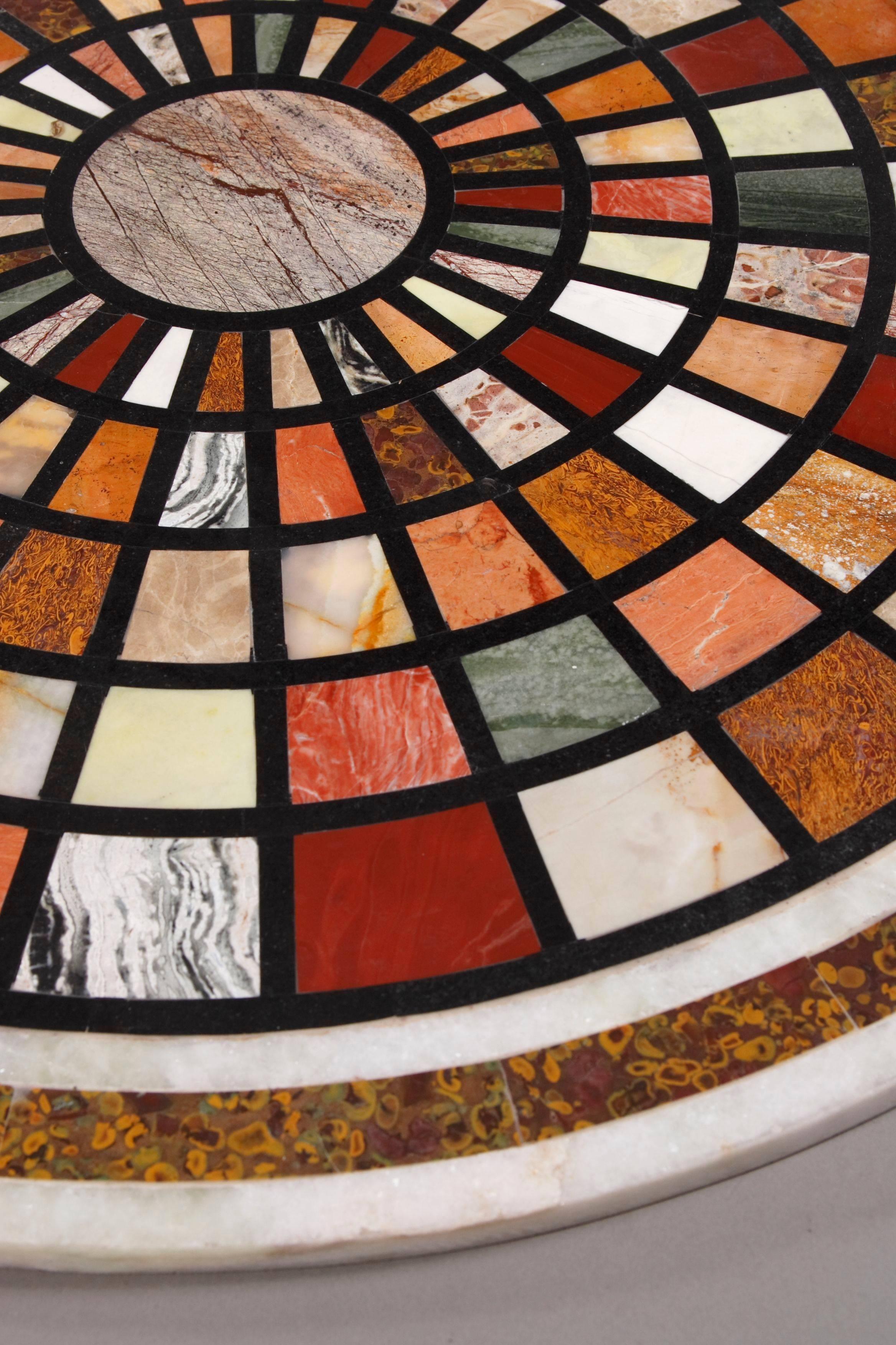 Pietra dura table platter in Classicist style.
Colored inlaid mosaic pattern in facet shape with in itself tapered optic towards the middle. Inlaid with highly valuable semi precious stones such as Cornelian, Coral, Jasper, Lapis Lazuli and other