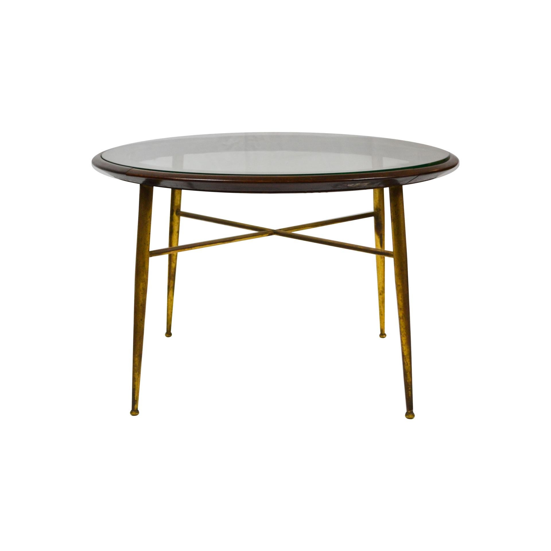 Coffee table in brass, wood and circular glass top, designed in 1950s in Italy. Patina of time in brass structure, original in all its parts, good condition.