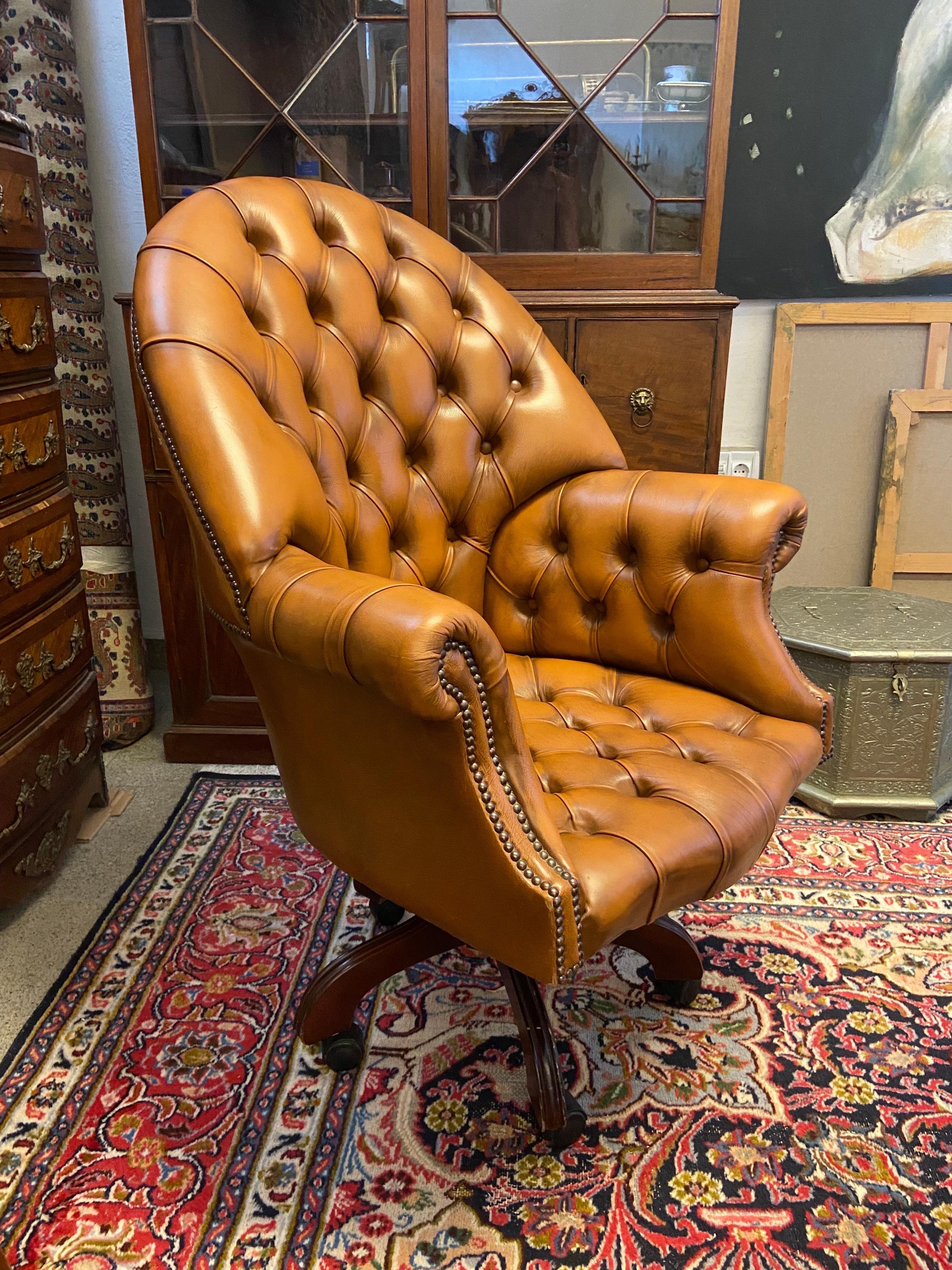 Exeptional aged cognac brown leather armchair Chesterfield tufted all over raised on original four leg swivel base on castors, circa 1920’s.
 