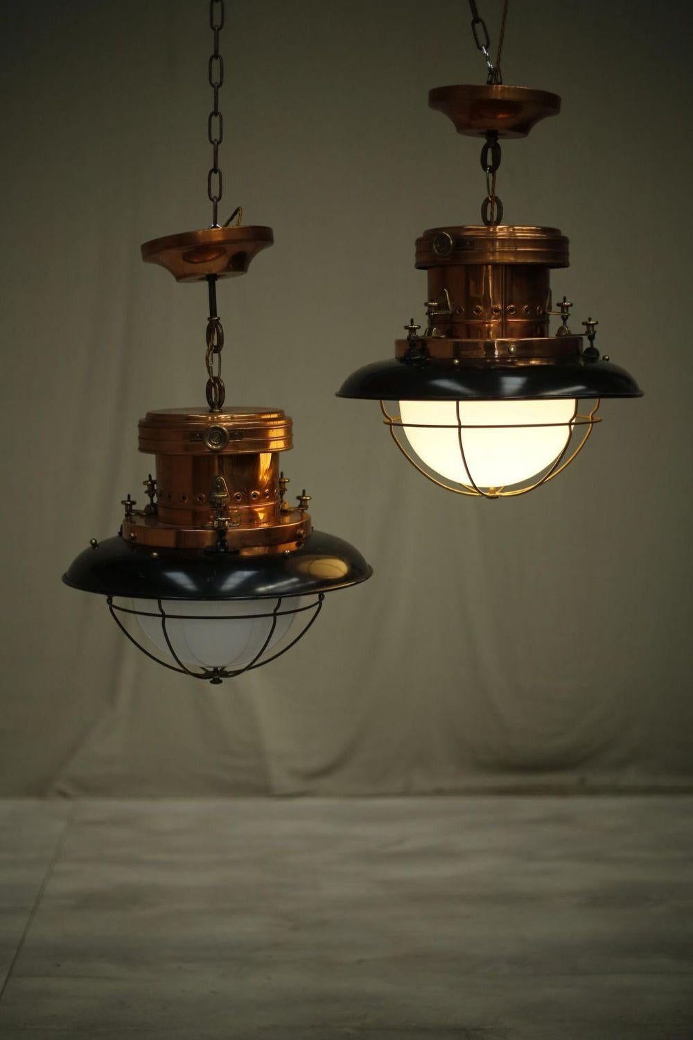 These are a stunning set of mid 20th century copper and black enamel pendant lights with opaline glass shade. These are most likely from a railway station and have gained a very attractive patina over the years. They are all in very good condition