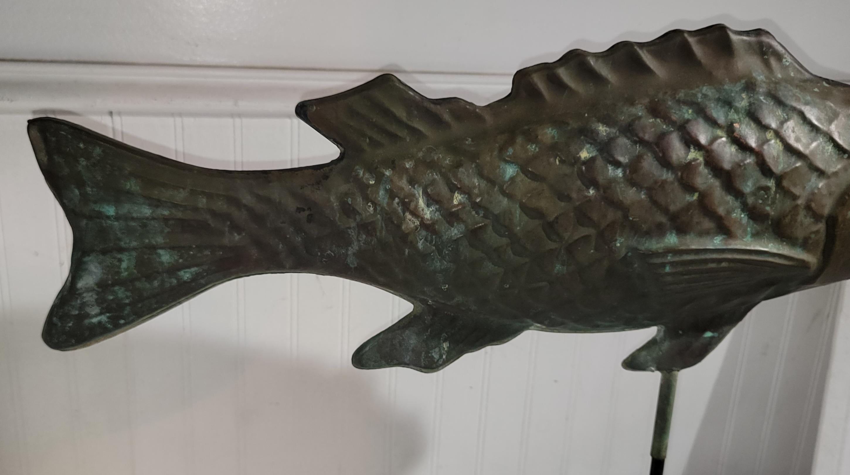 Early 20thc Hollow Body  fish weather vane made from copper with a nice aged patina custom base/stand made for the fish. This weather vane was found in Cape Cod. 
Has a cast iron base.
Measurements of copper fish are 26w x 12h x 5d.