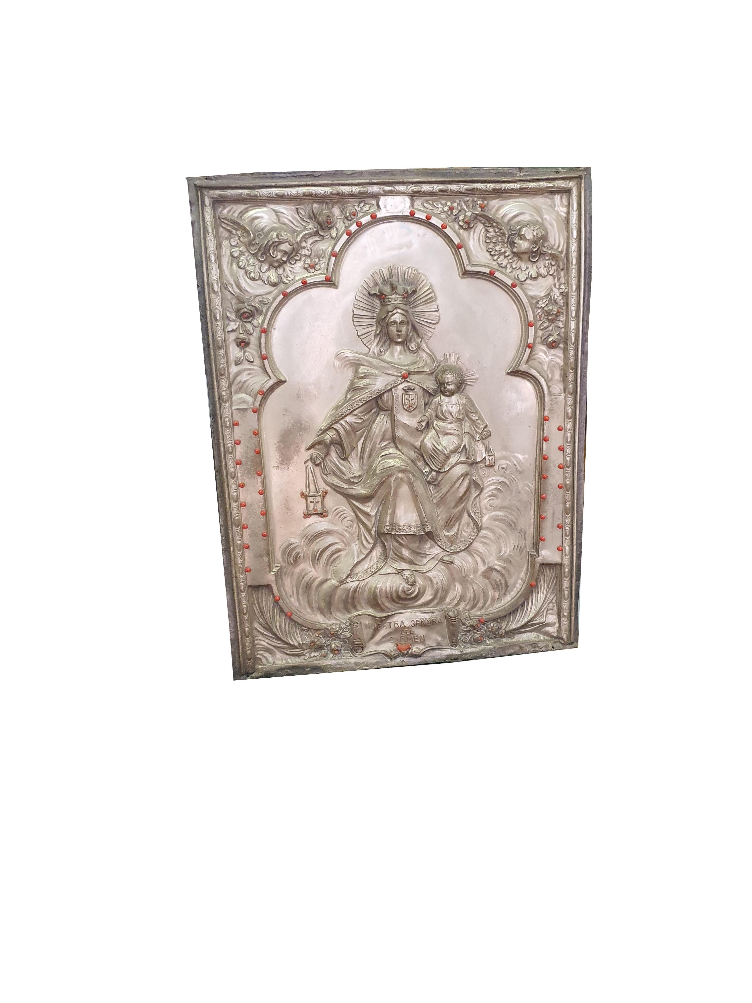 Plaque particulière en cuivre argenté, représentant la Madonna del Carmine, avec des inserts en corail de Trapani. Ci-dessous nous trouvons les mots 