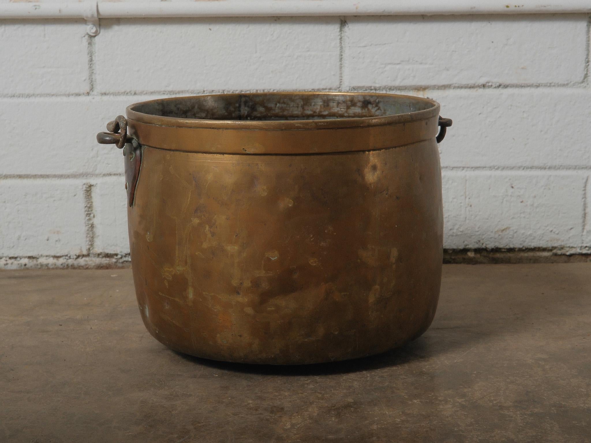 A substantial hand-forged copper vessel, celebrated for its sculptural silhouette and warm, time-worn patina. Crafted with thick walls and a softly rounded form, this piece embodies the quiet elegance of utilitarian metalwork. The surface reveals a