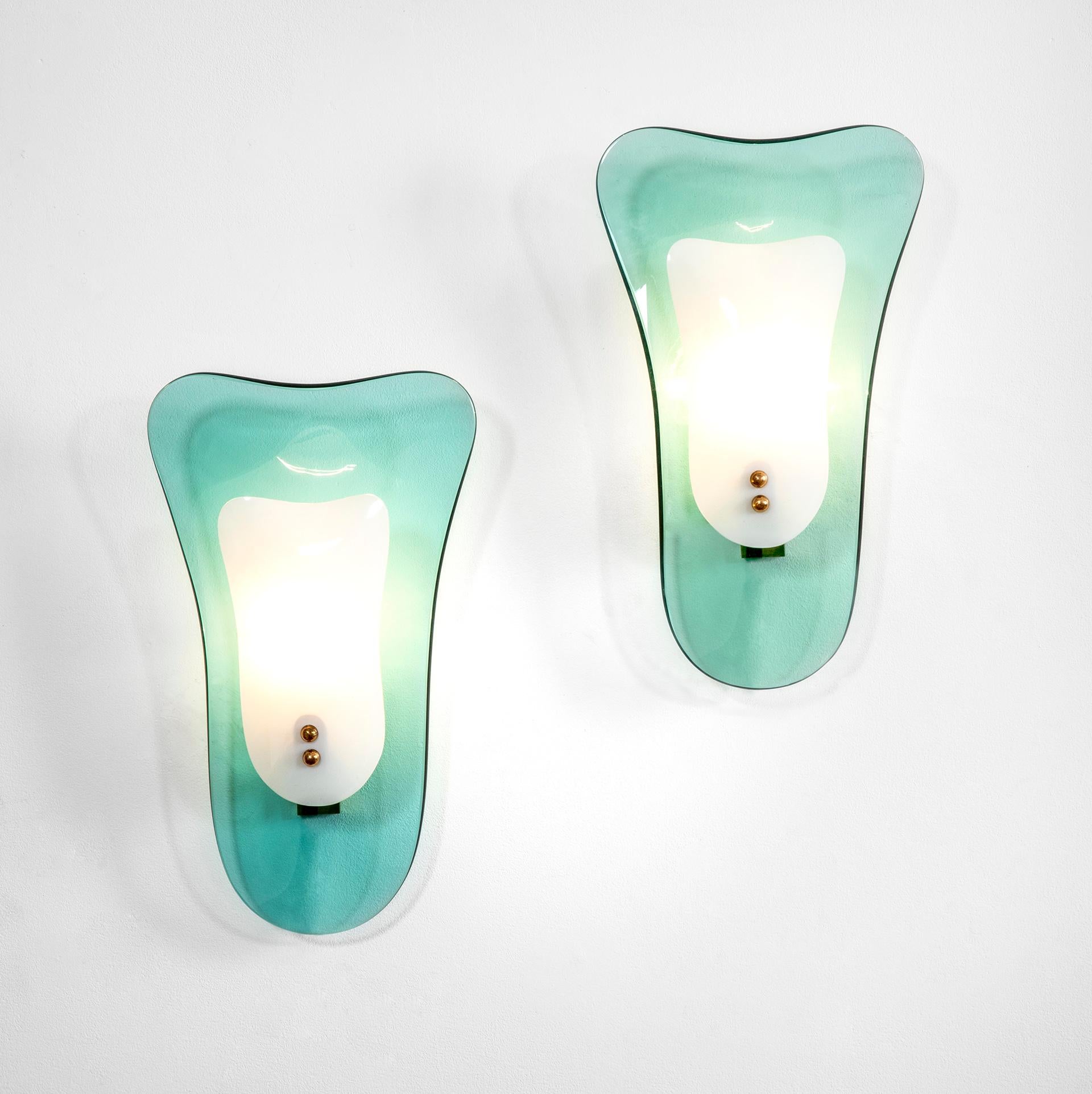 Couple of wall lights / sconces designed in '50s by the italian manufacturer Cristal Arte.
Each piece has a brass structure hidden by two glasse, the back glass is in transparent / green glass, the front glass is opaline. Details in brass.
Good