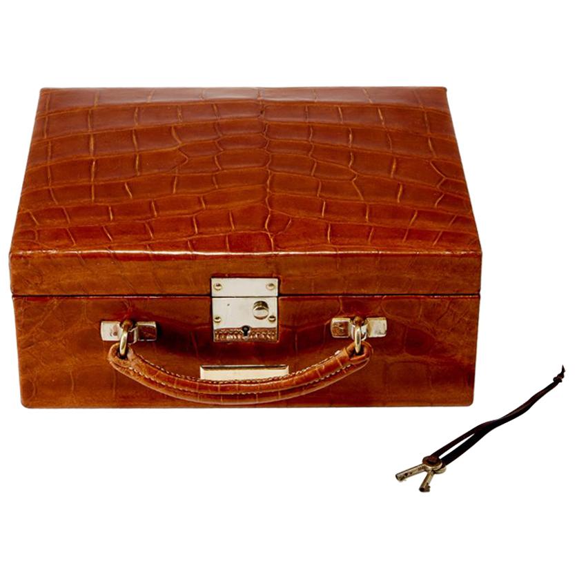 Discover a rare find with this antique 20th Century jewellery travel case, dating back to circa 1930. 

Impressively preserved, this piece appears unused, retaining its original crocodile skin patina on the exterior, including the base.

Inside, the