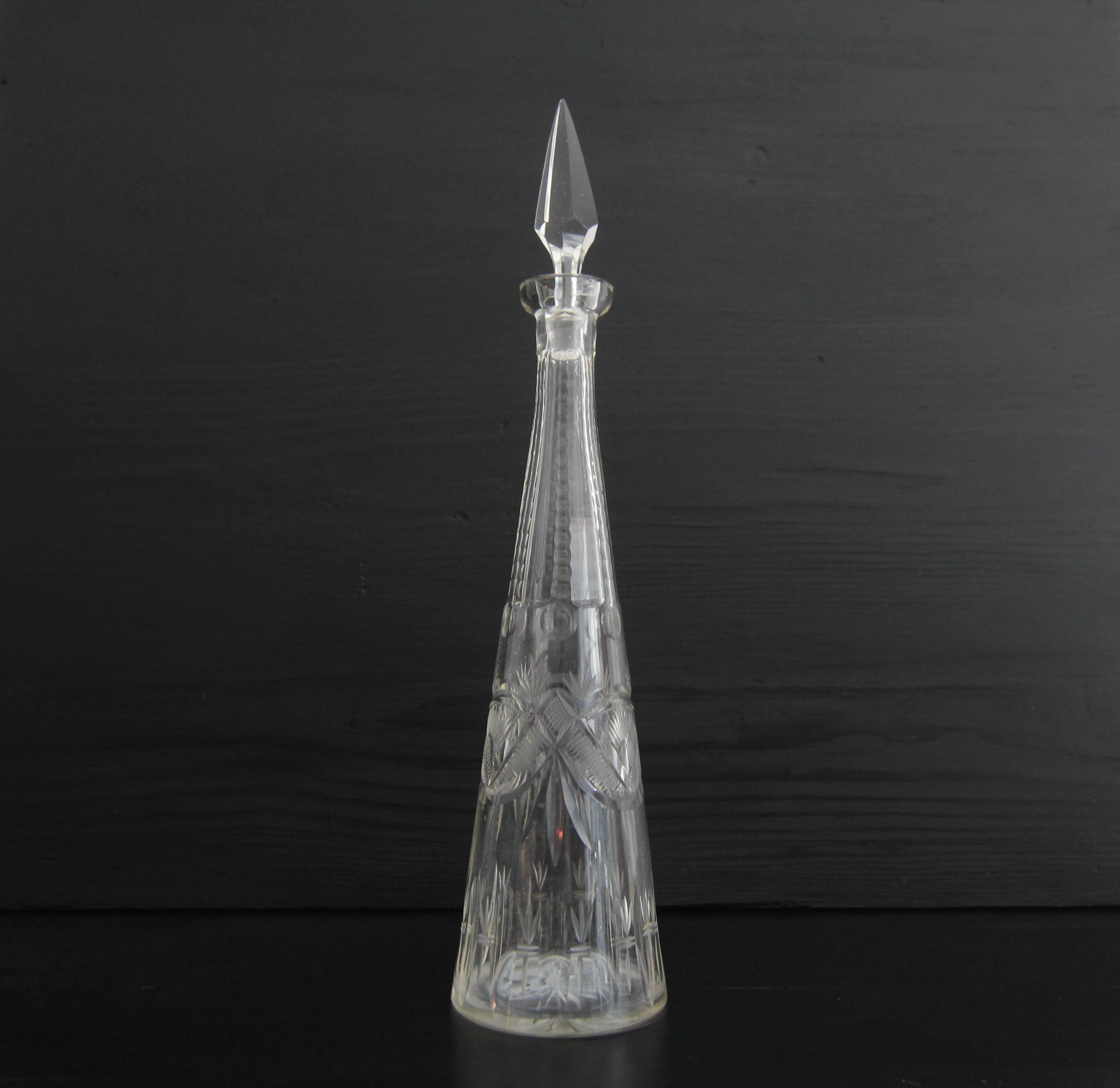 Une carafe en verre de cristal conique avec une coupe en biseau. Probablement des années 1960. 

L'artisanat traditionnel du soufflage et de la découpe du verre transforme le cristal en un objet sophistiqué caractérisé par sa clarté et sa brillance.