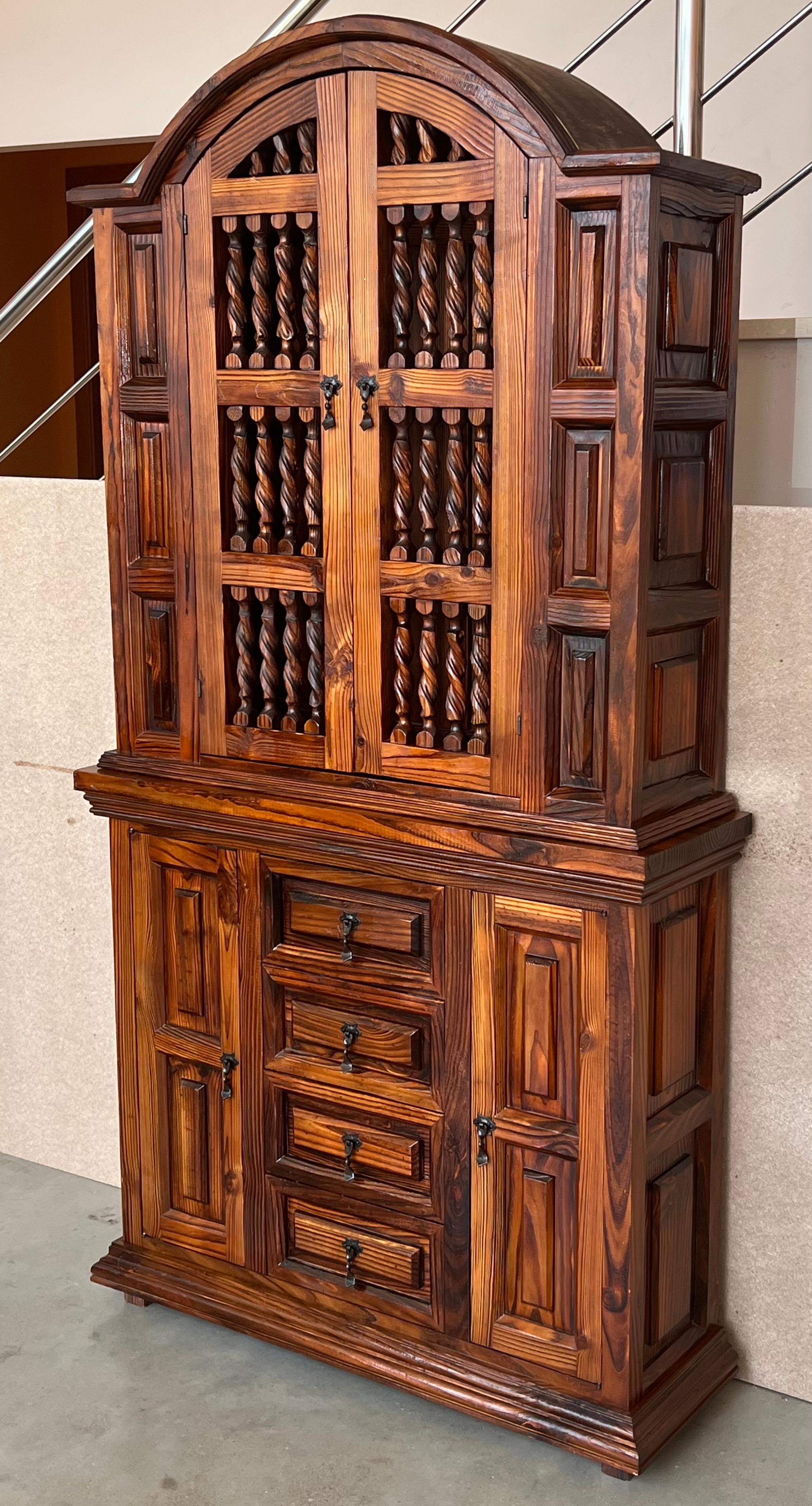 Grand 20th century Spanish cabinet constructed from pine. Features a coffered case fronted by two doors in the high part and four drawers and two doors in the low part. This massive cabinet made in Spain features beautiful walnut grain and showcases