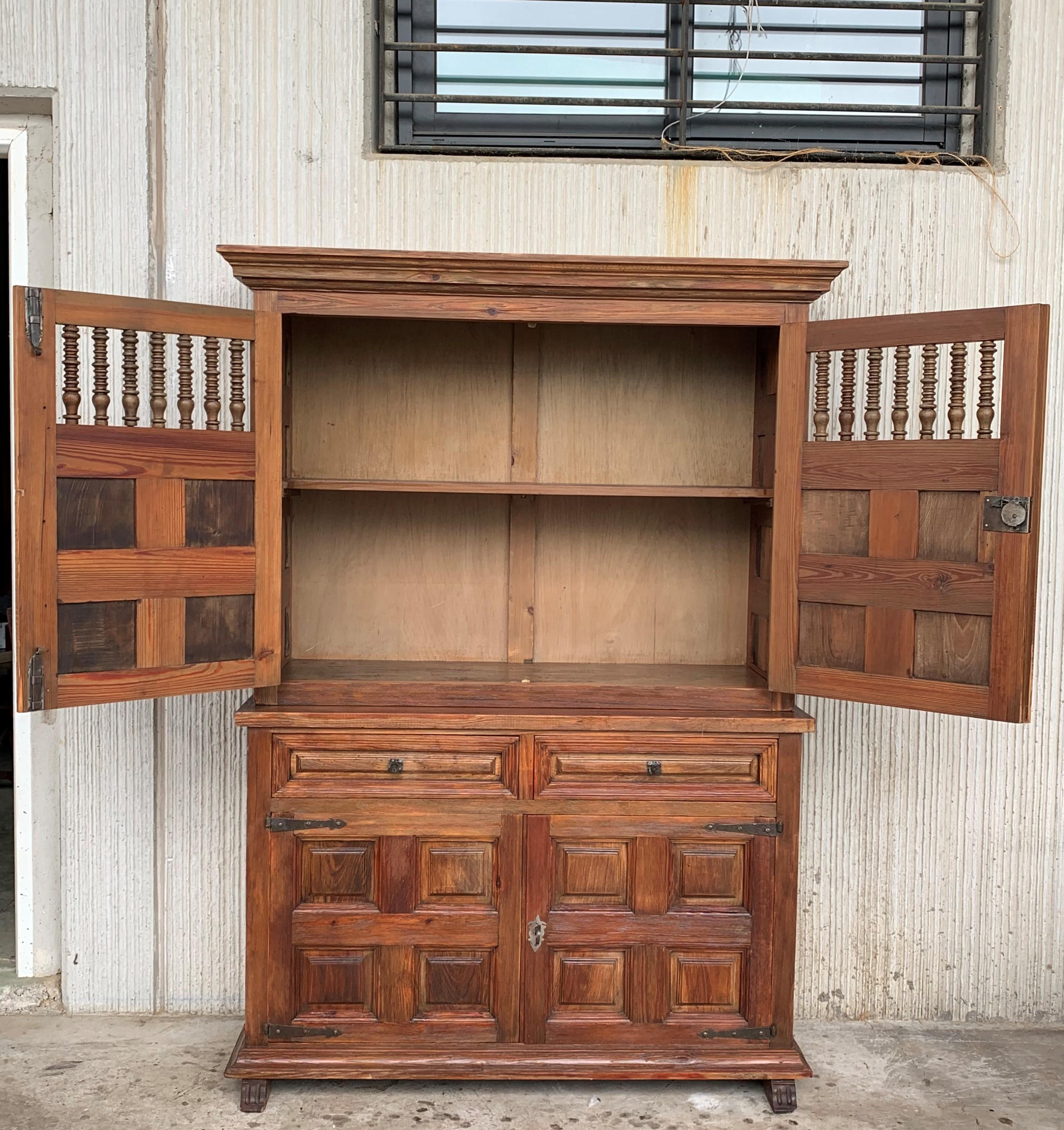 Grand 20th century Spanish cabinet constructed from pine. Features a coffered case fronted by two doors in the high part and two doors in the low part. This massive cabinet made in Spain features beautiful walnut grain and showcases the amazing