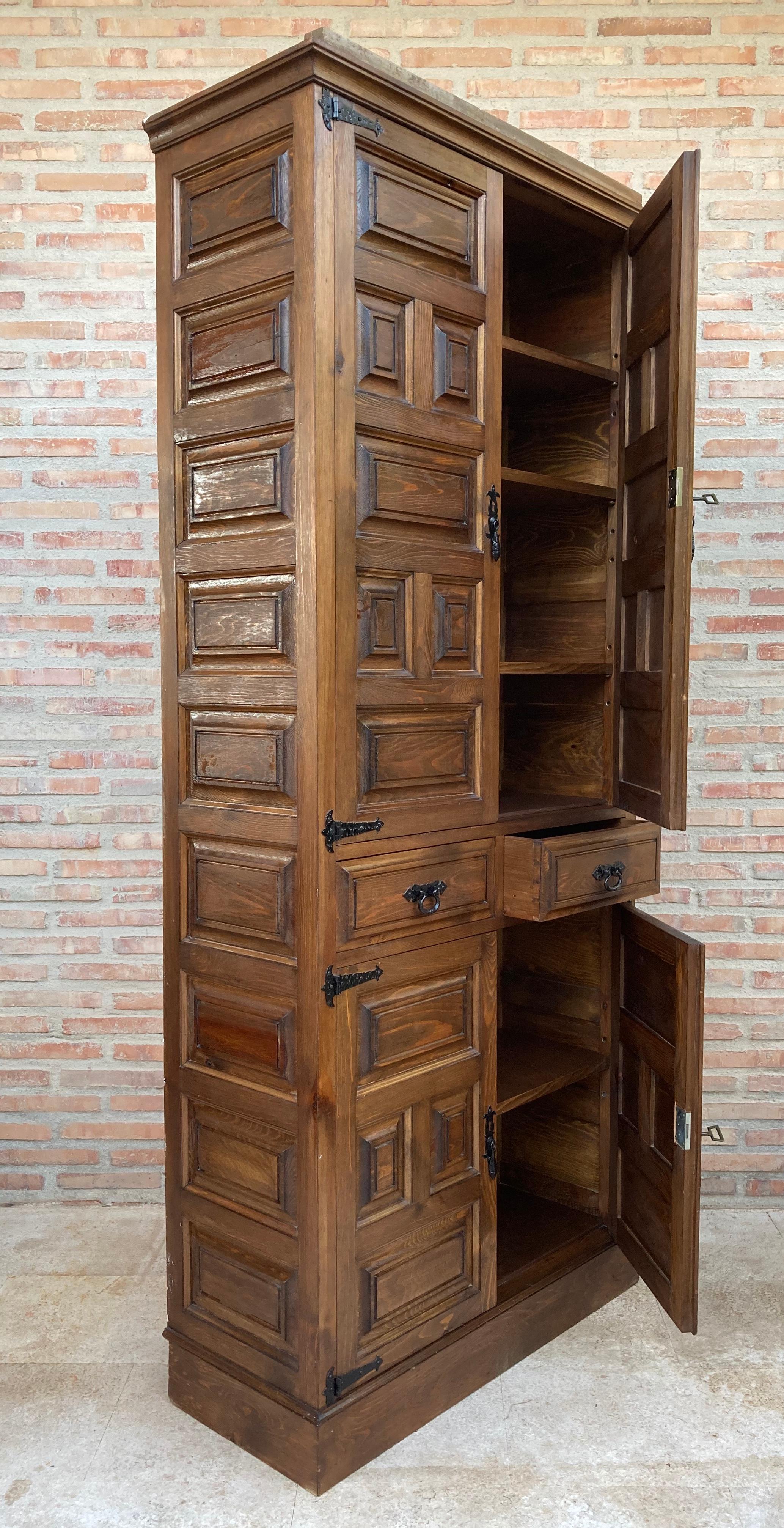 Grand 20th century Spanish armario or wardrobe armoire constructed from walnut. Features a coffered case fronted by two doors. This massive cabinet made in Spain features beautiful walnut grain and showcases the amazing craftsmanship. There is a