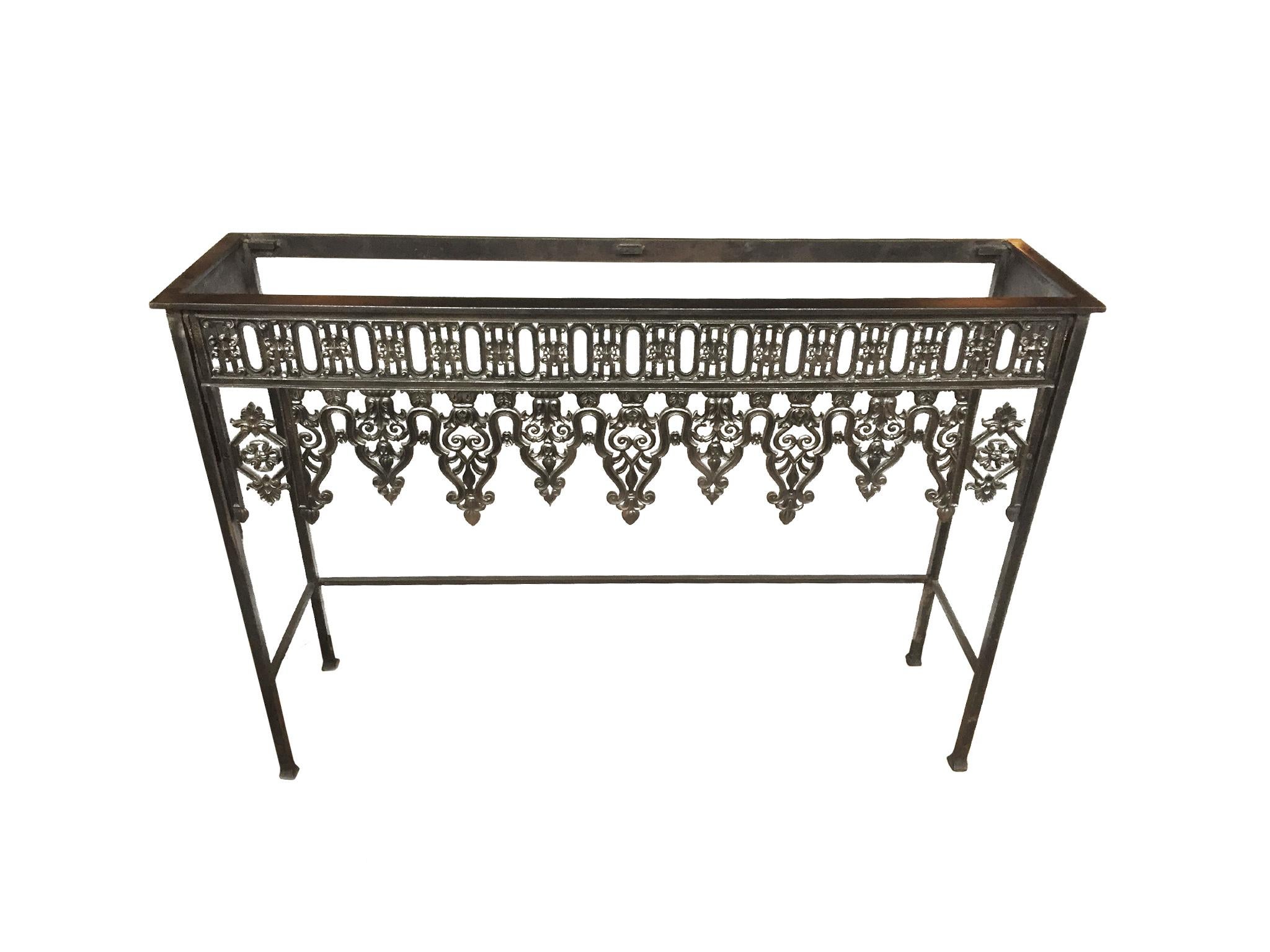 This 20th century console table is comprised of a steel frame, a glass top insert, and wrought iron grillwork. The grillwork itself is antique, circa mid-late 19th century. This marriage of old and new, custom designs creates an elegant combination